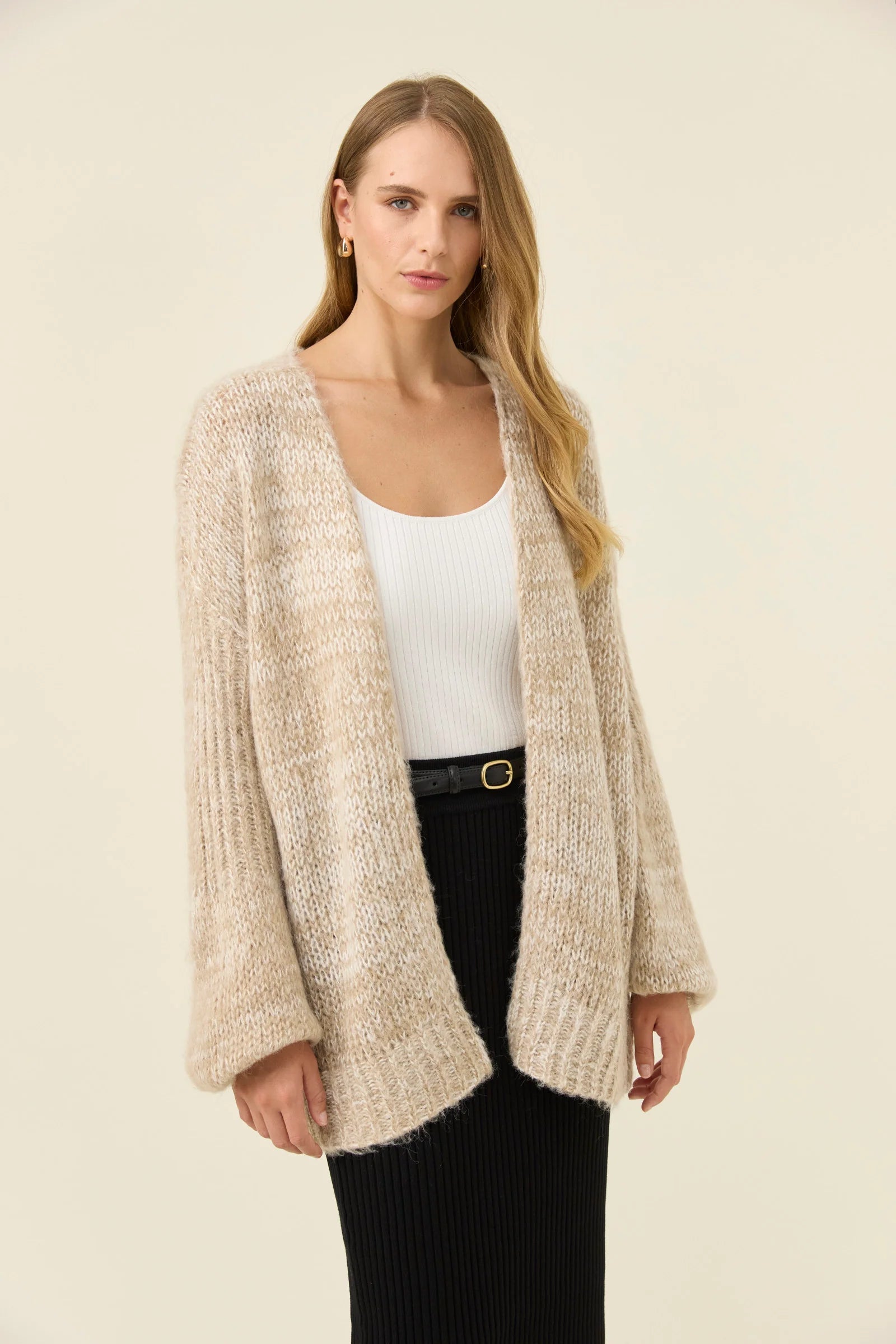 Woman pictured wearing Isle of Mine relaxed cardigan paired with black skirt on a plain background