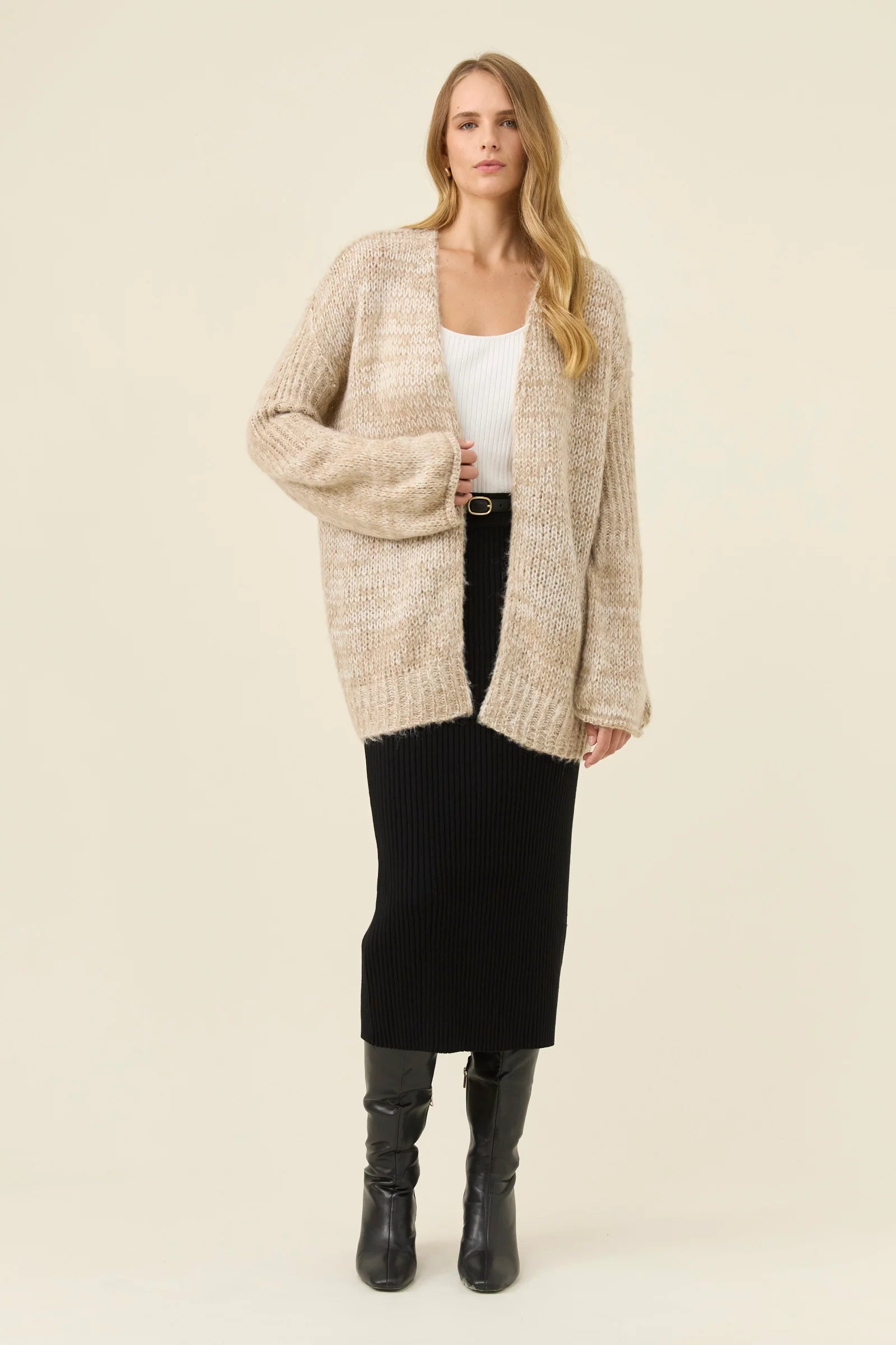 Woman pictured wearing Isle of Mine relaxed cardigan paired with black skirt on a plain background