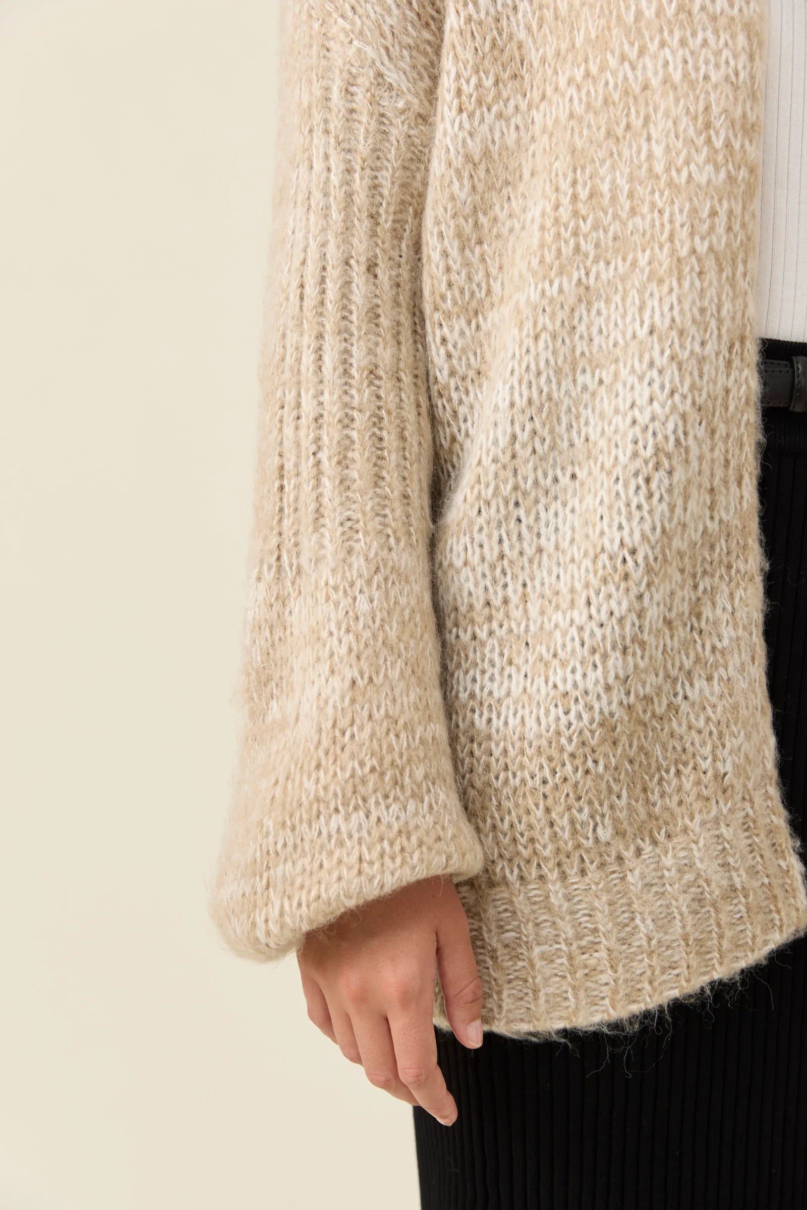Woman pictured wearing Isle of Mine relaxed cardigan paired with black skirt on a plain background
