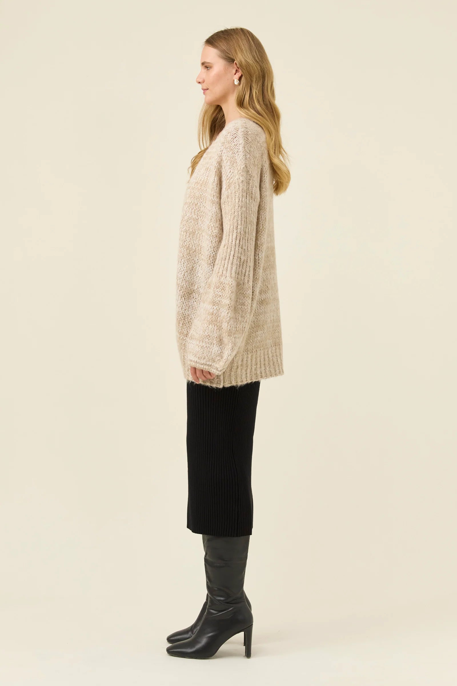 Woman pictured wearing Isle of Mine relaxed cardigan paired with black skirt on a plain background