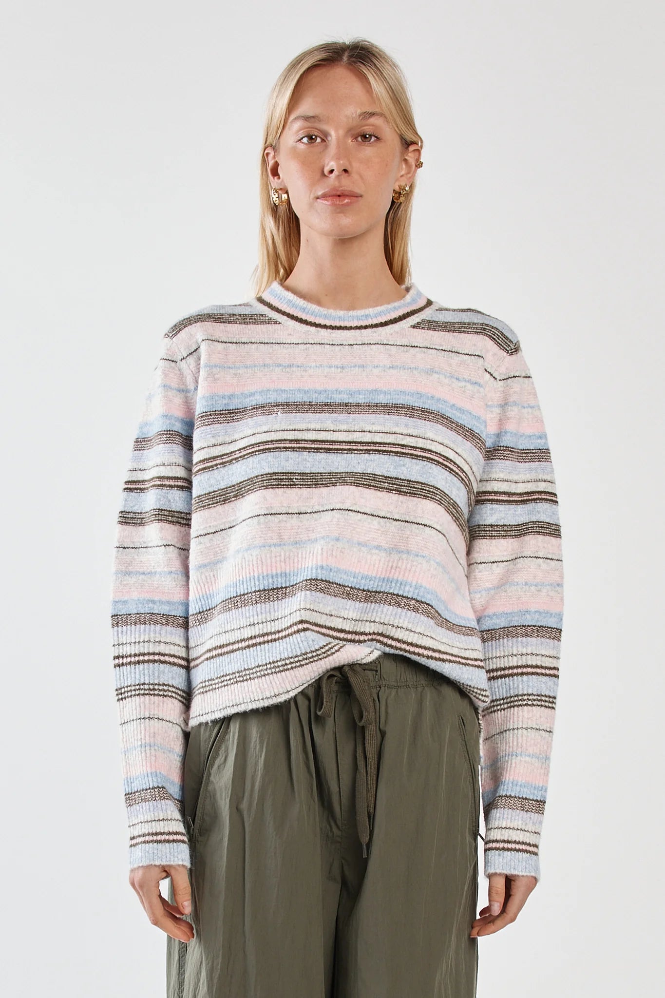 Image of Woman wearing a Sass striped sweater and green pants on a white background