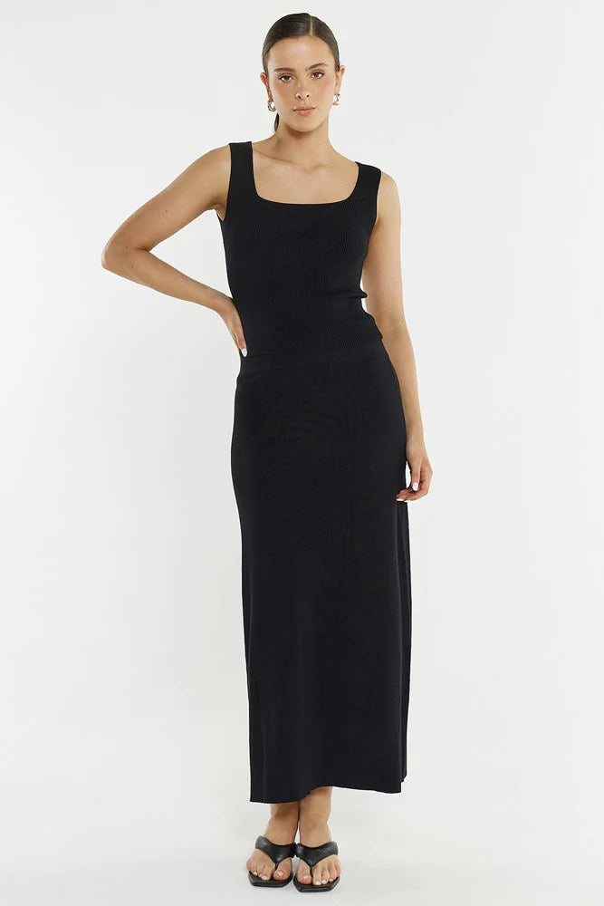 Woman wearing a Sass black knit skirt on a white background
