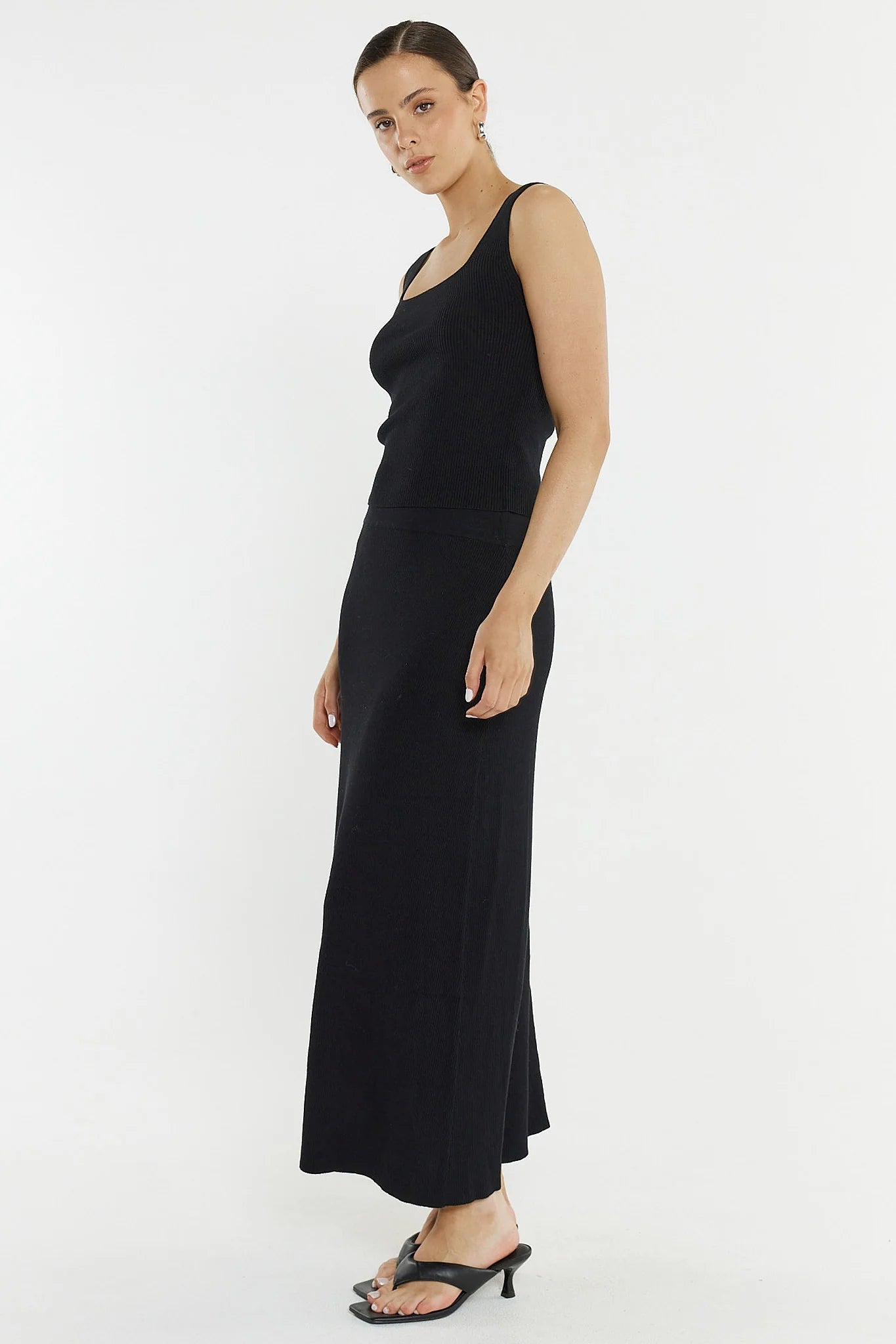 Woman wearing a Sass black knit skirt on a white background