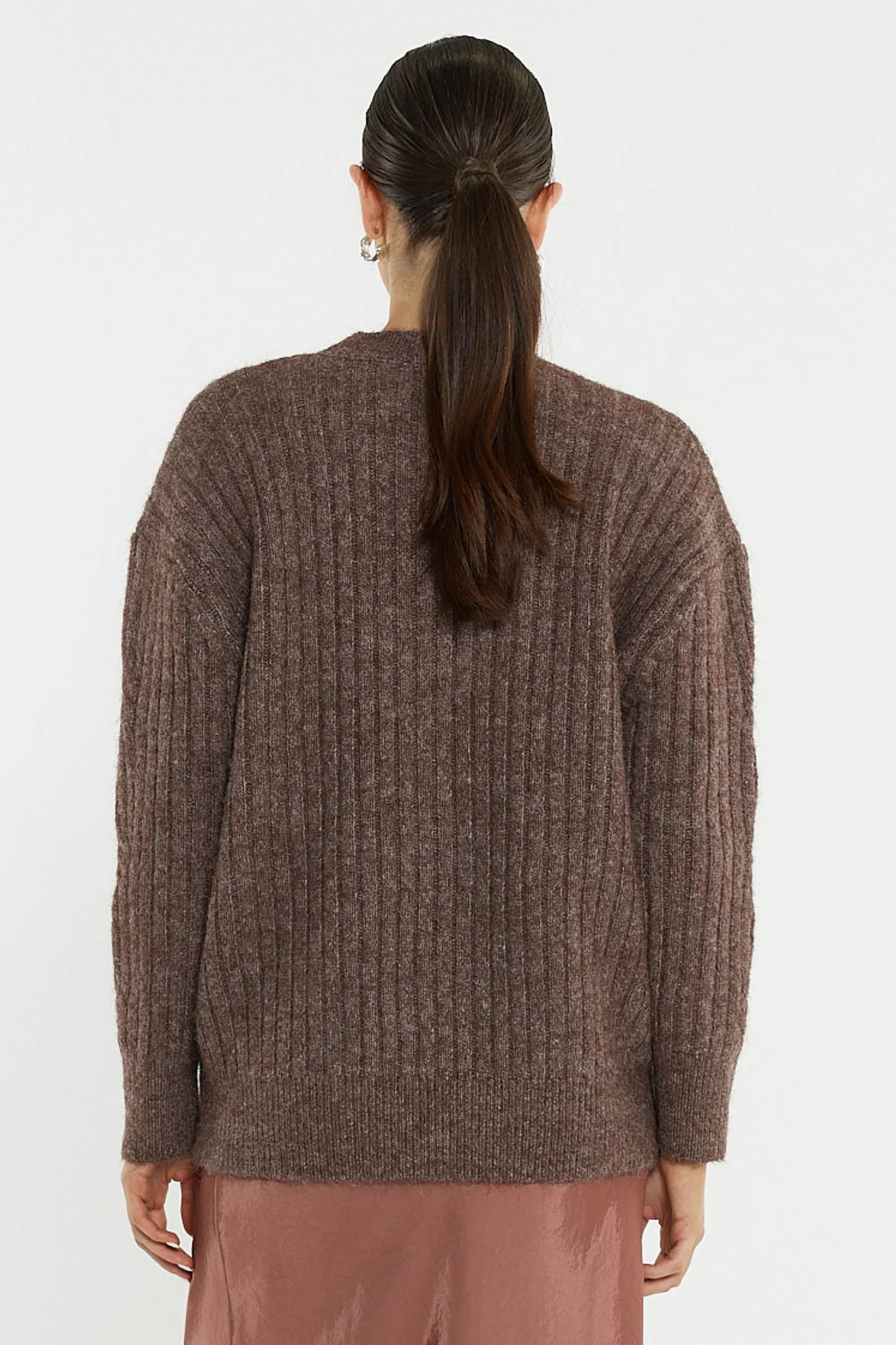 Woman wearing a Sass brown sweater from behind on a white background