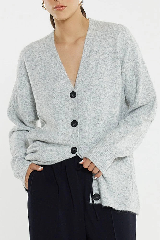 Woman wearing a Sass grey cardigan with black buttons on a white background