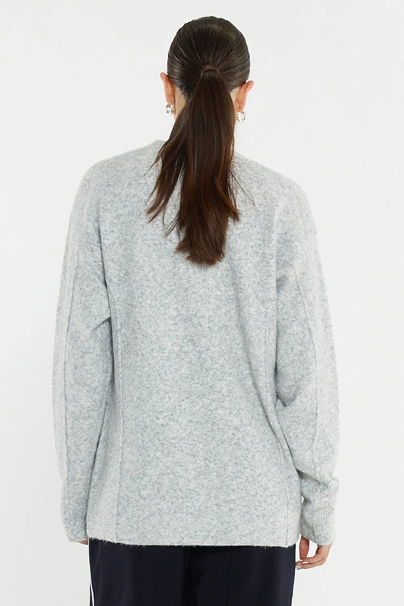 Image of Woman wearing a Sass grey sweater on a white background