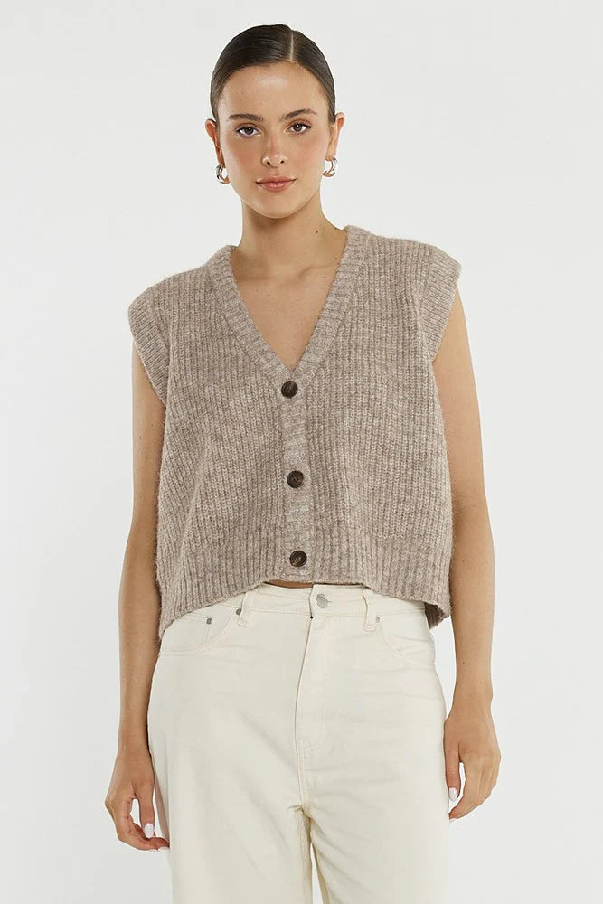 Image of Woman wearing a Sass sleeveless knitted vest with buttons on a white background