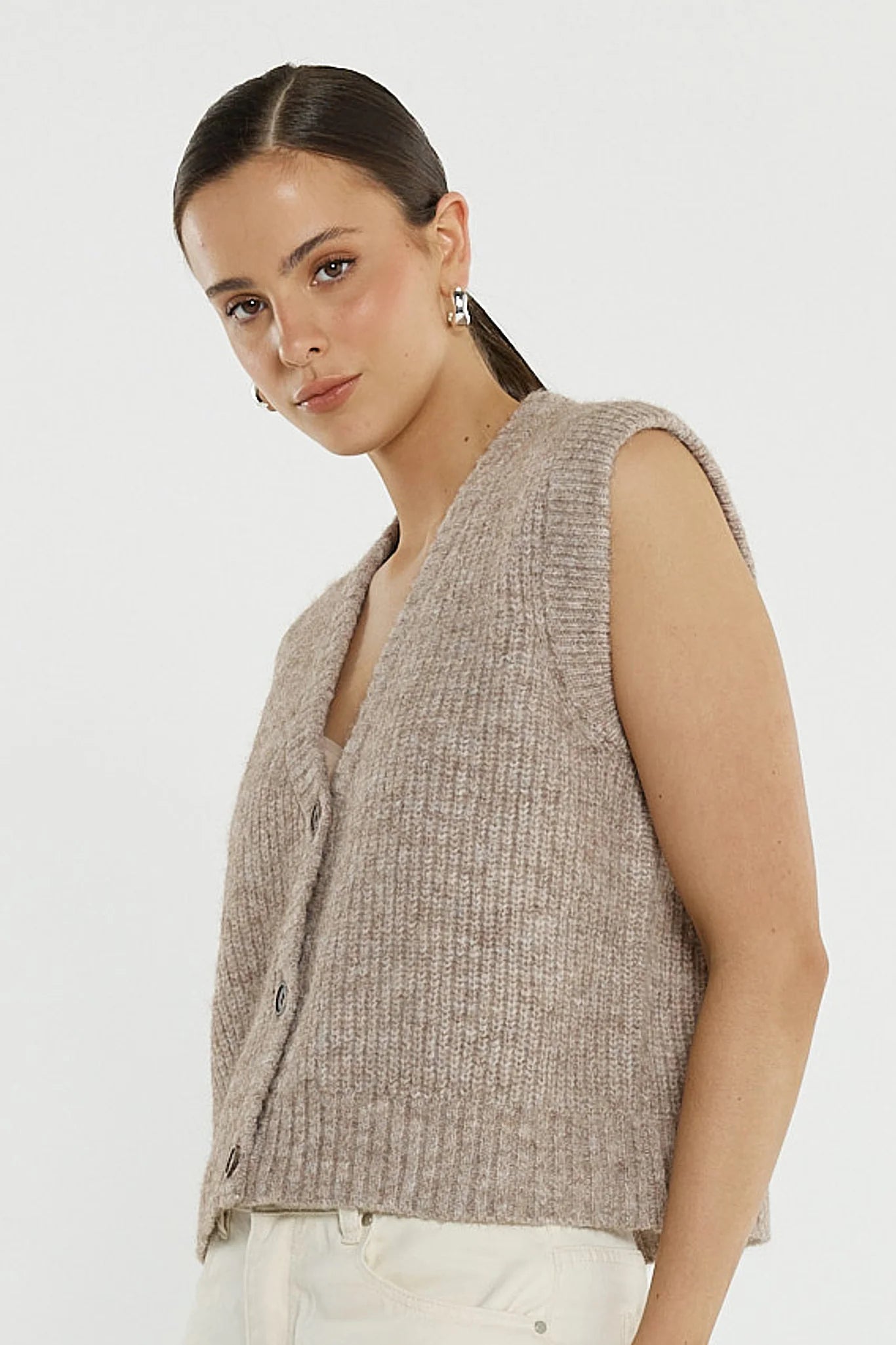 Image of Woman wearing a Sass beige knitted vest against a white background