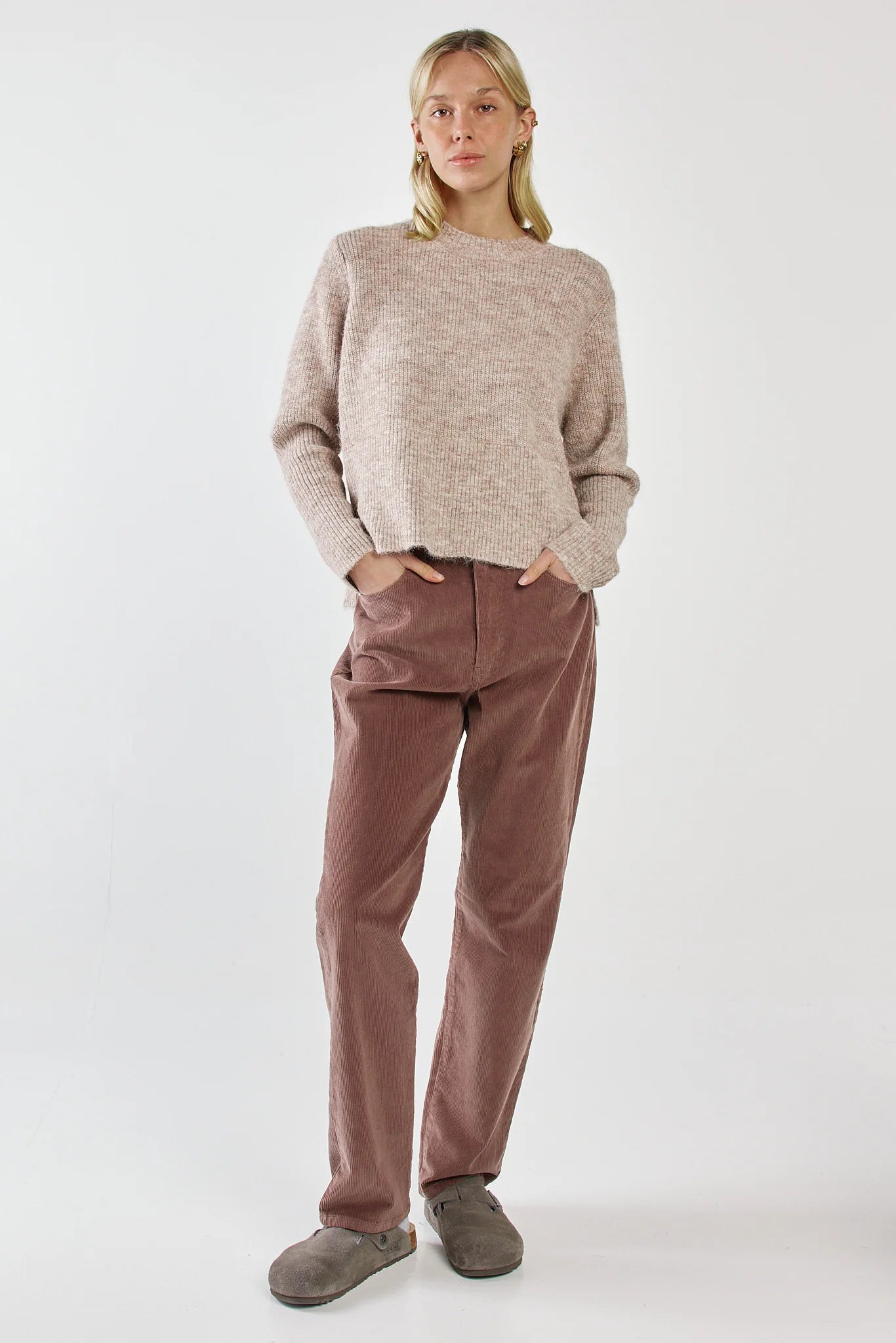 Image of Woman wearing a Sass beige sweater and brown pants on a white background
