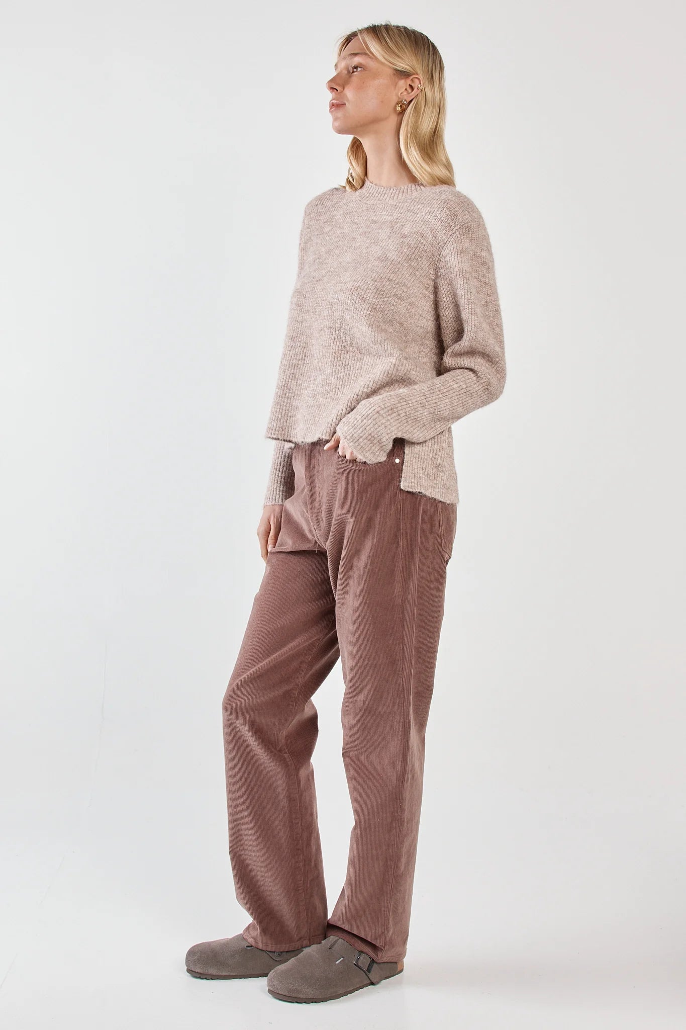 Image of Woman wearing a Sass beige sweater and pink pants on a white background