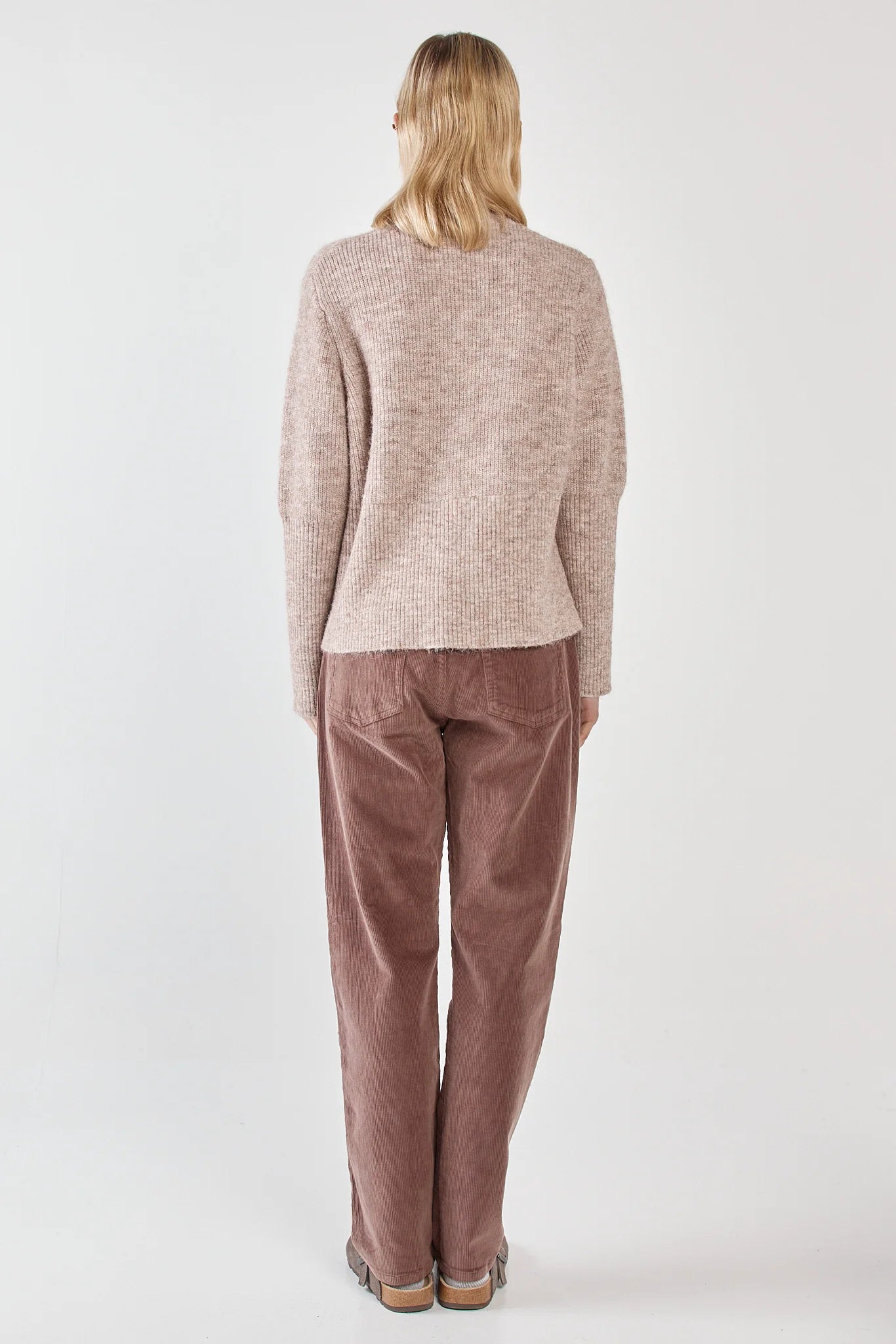 Image of Woman wearing a Sass beige sweater and brown pants on a white background