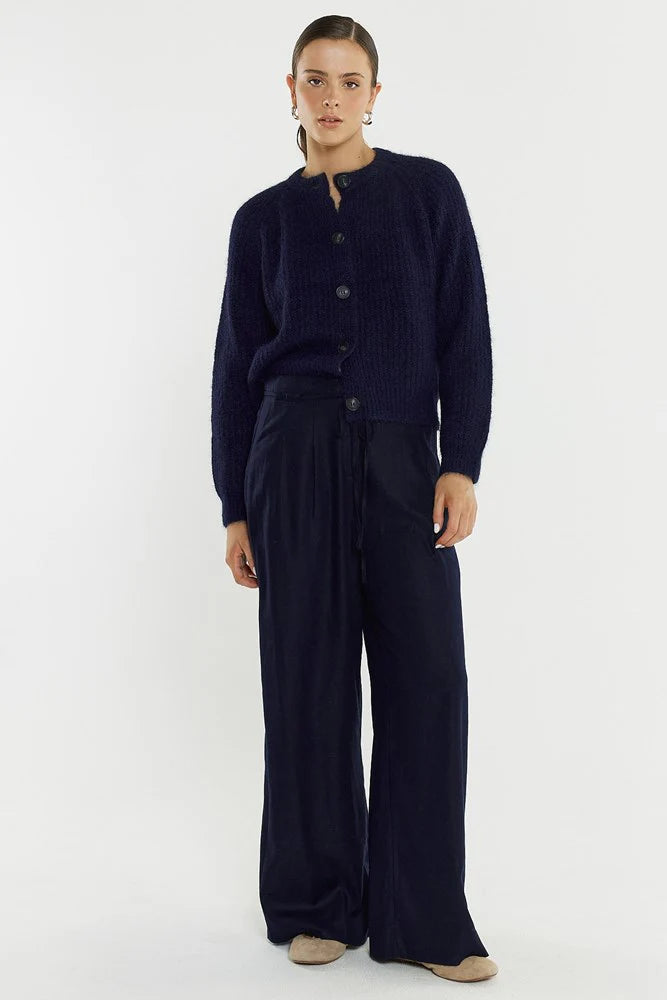 Image of Woman wearing a Sass navy blue cardigan and pants on a white background