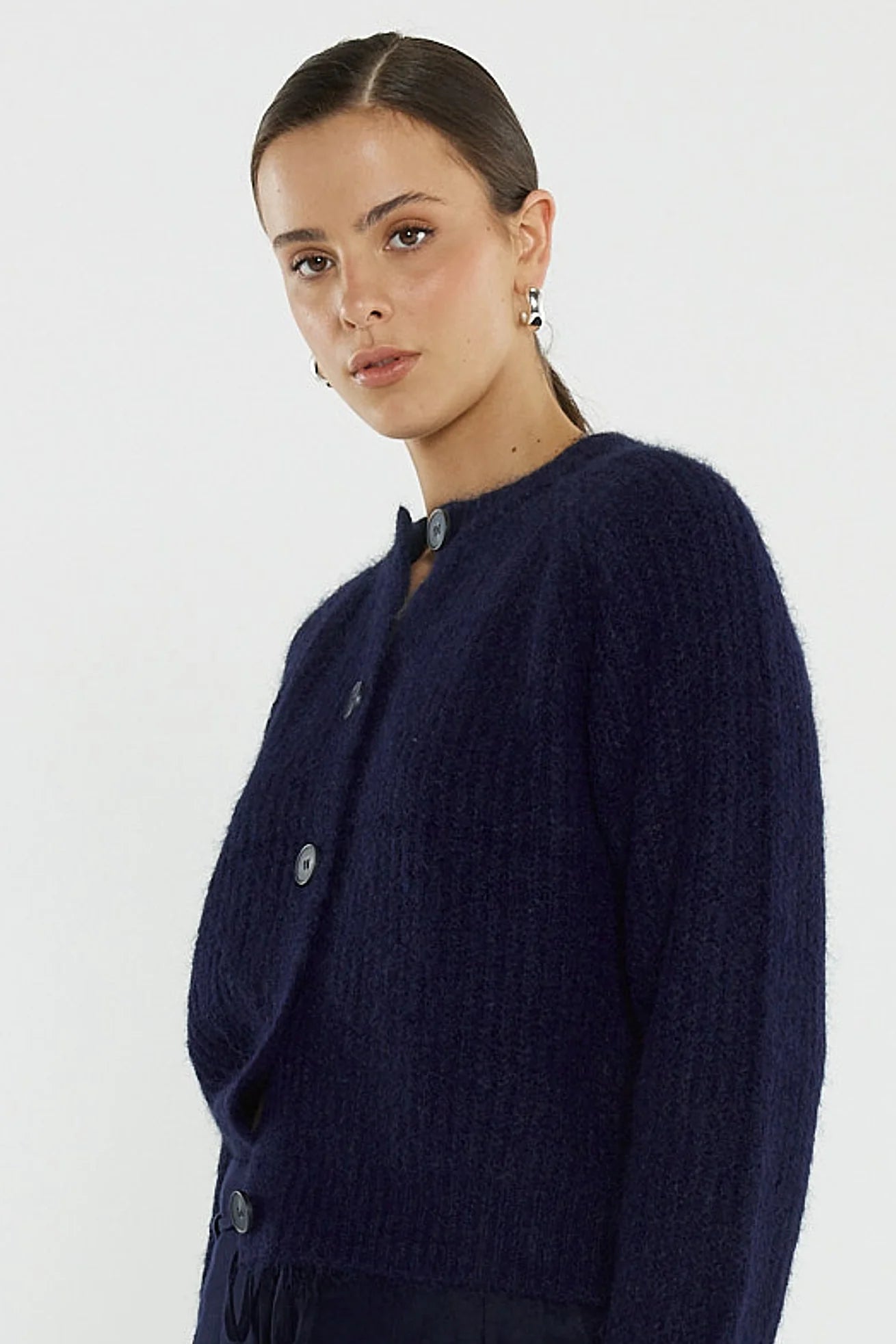 Image of Woman wearing a Sass navy blue cardigan on a white background