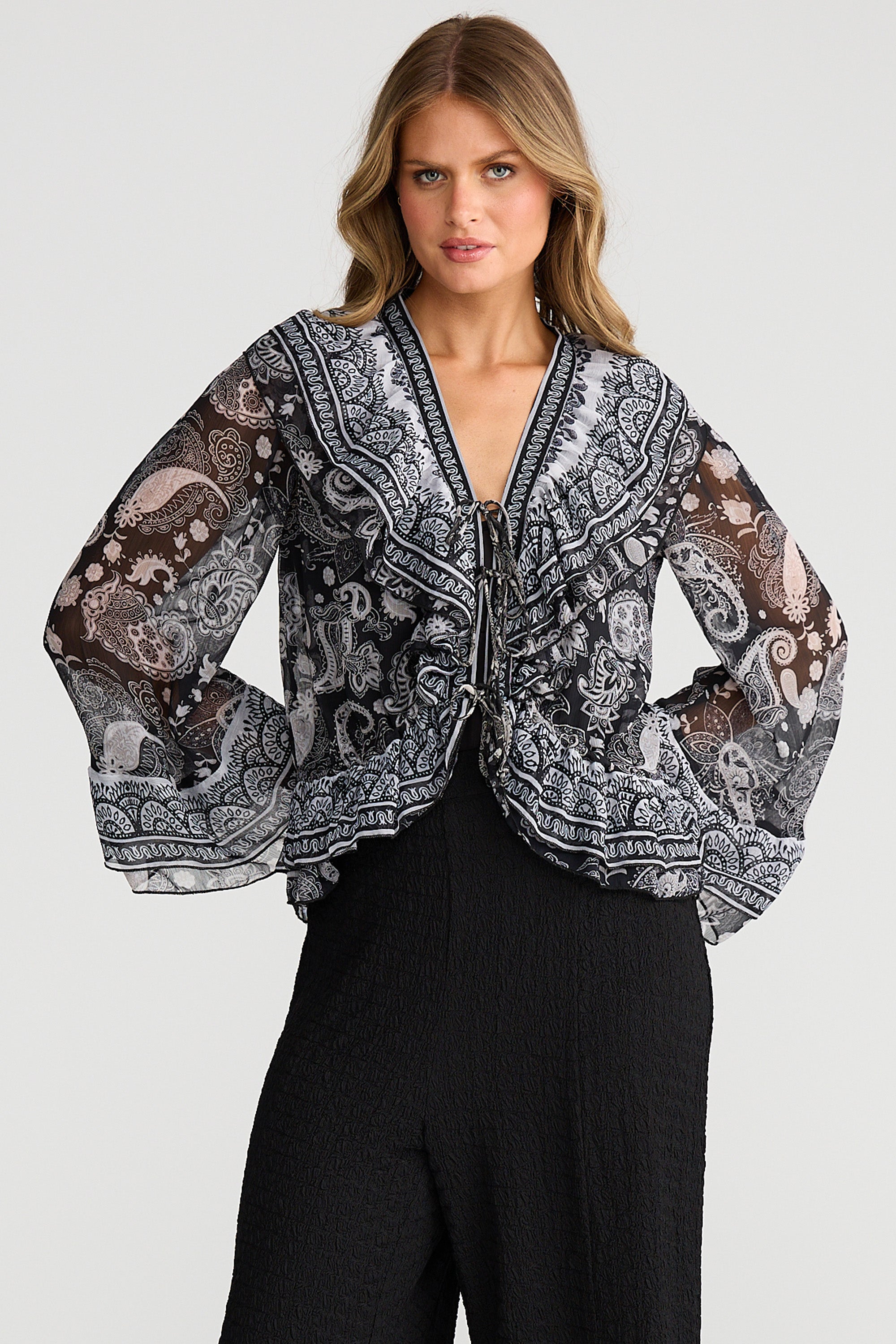 Collection of Woman wearing a Talisman patterned jacket and black pants on a light gray background in a gallery layout