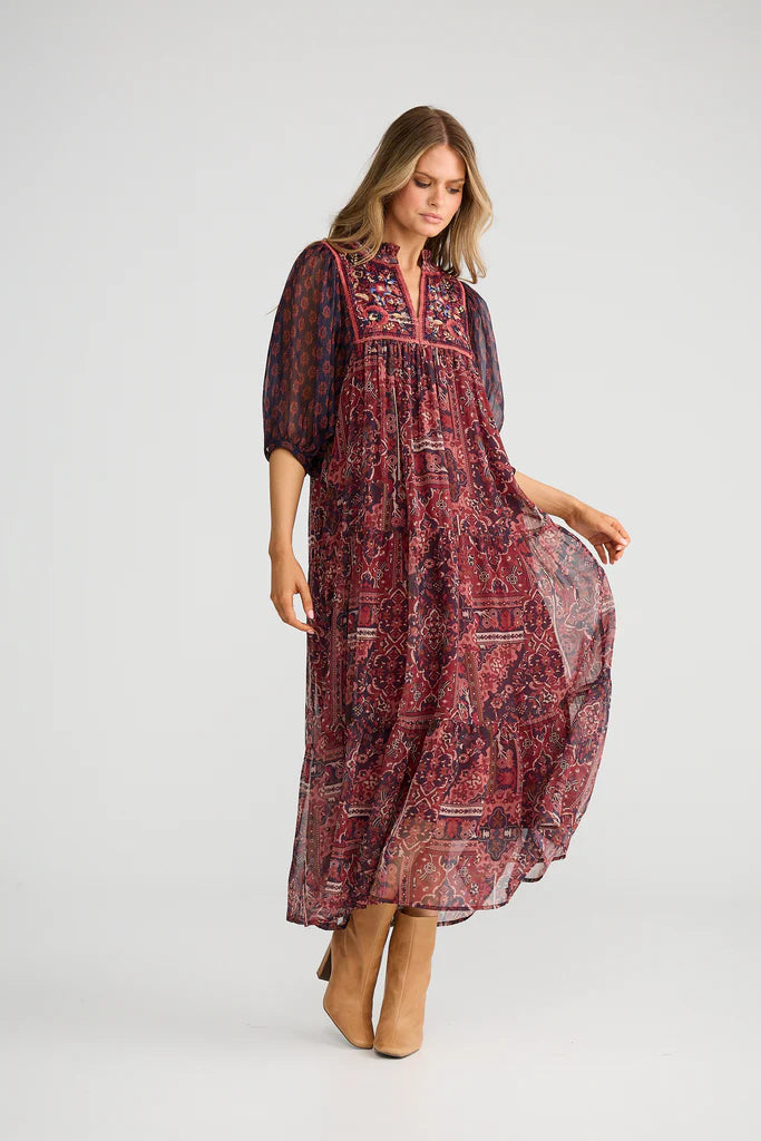 Image of Woman wearing a Talisman patterned dress on a white background