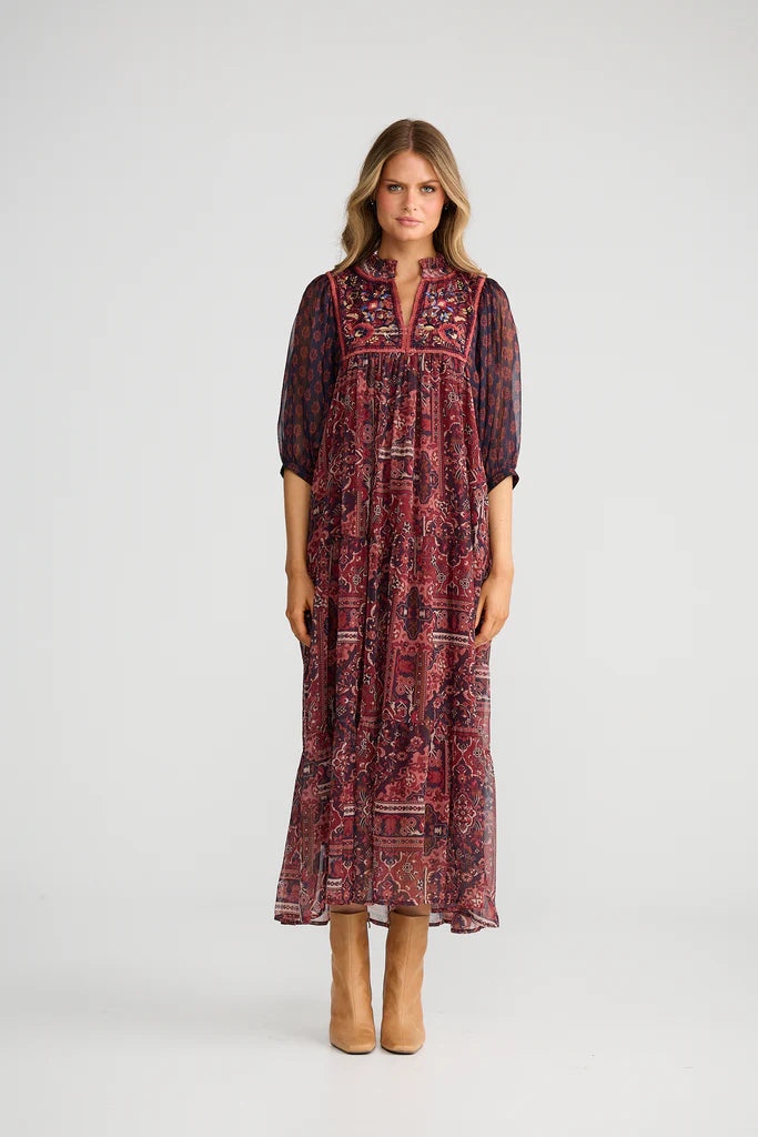 Woman wearing a Talisman patterned dress on a white background