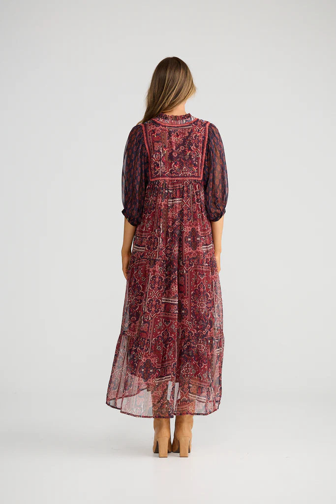 Image of Woman wearing a Talisman long patterned dress on a white background