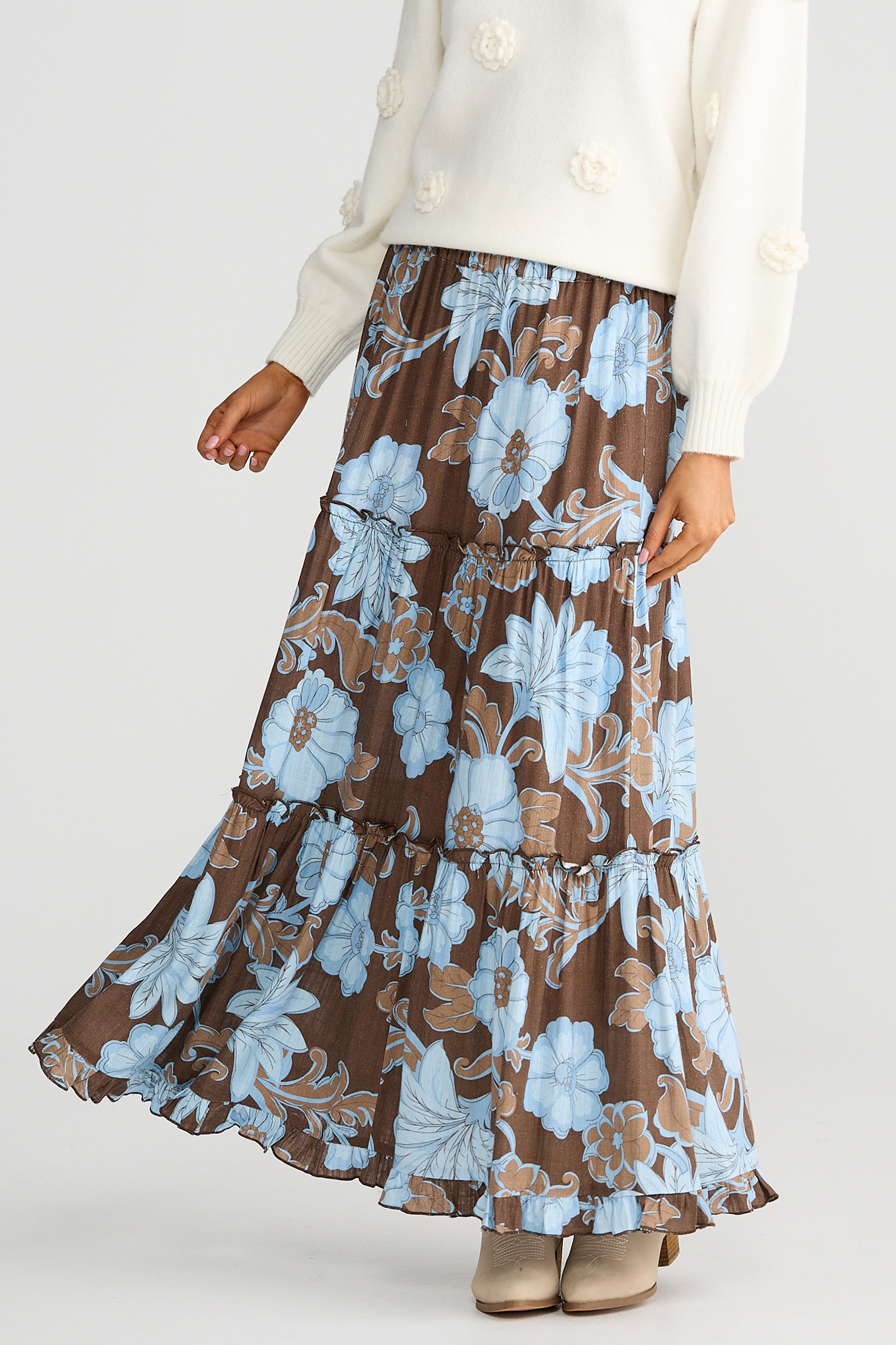Woman wearing a Talisman brown floral skirt with blue flowers on a white background