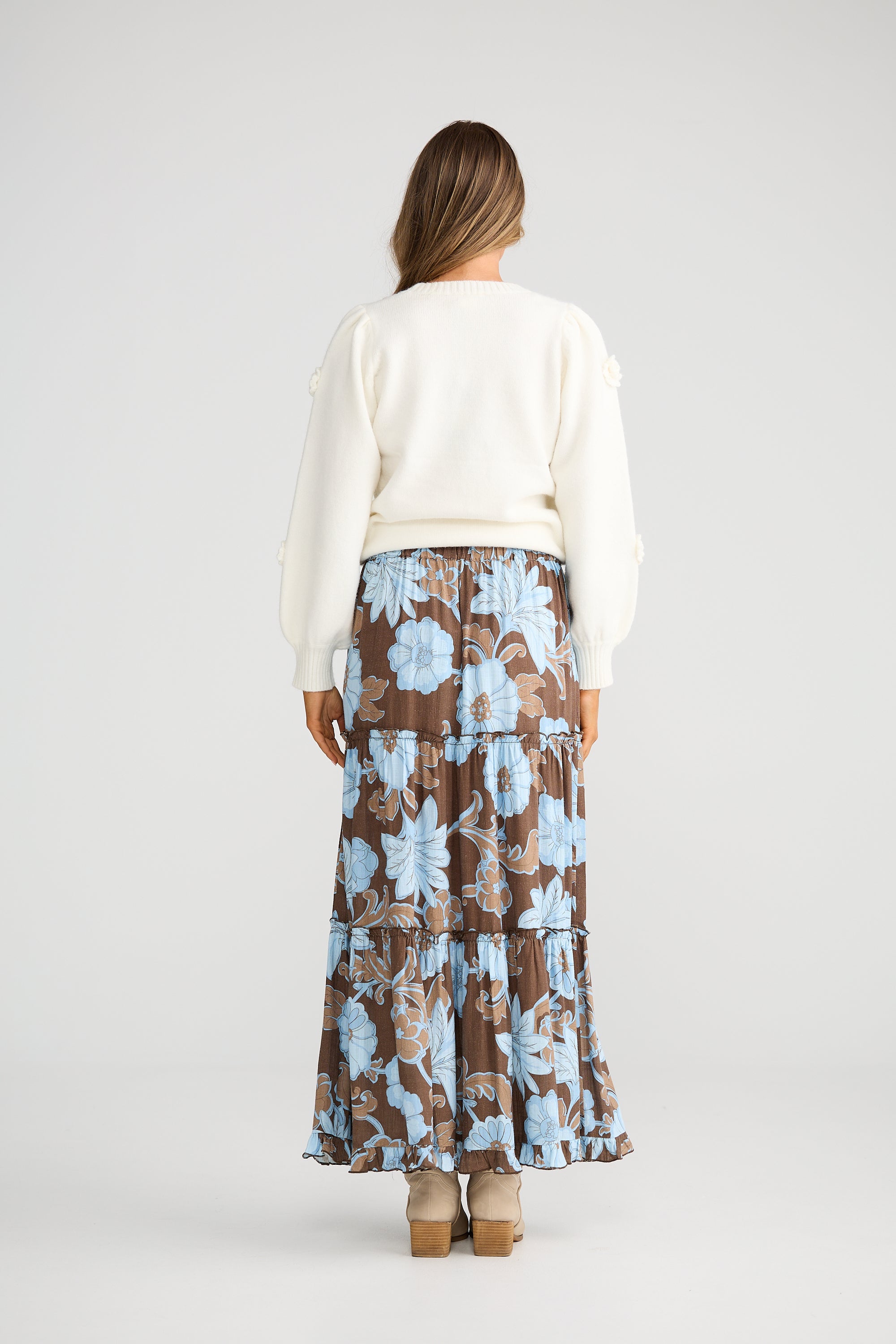 Collection of Woman wearing a white top and Talisman floral skirt on a plain background in a gallery layout