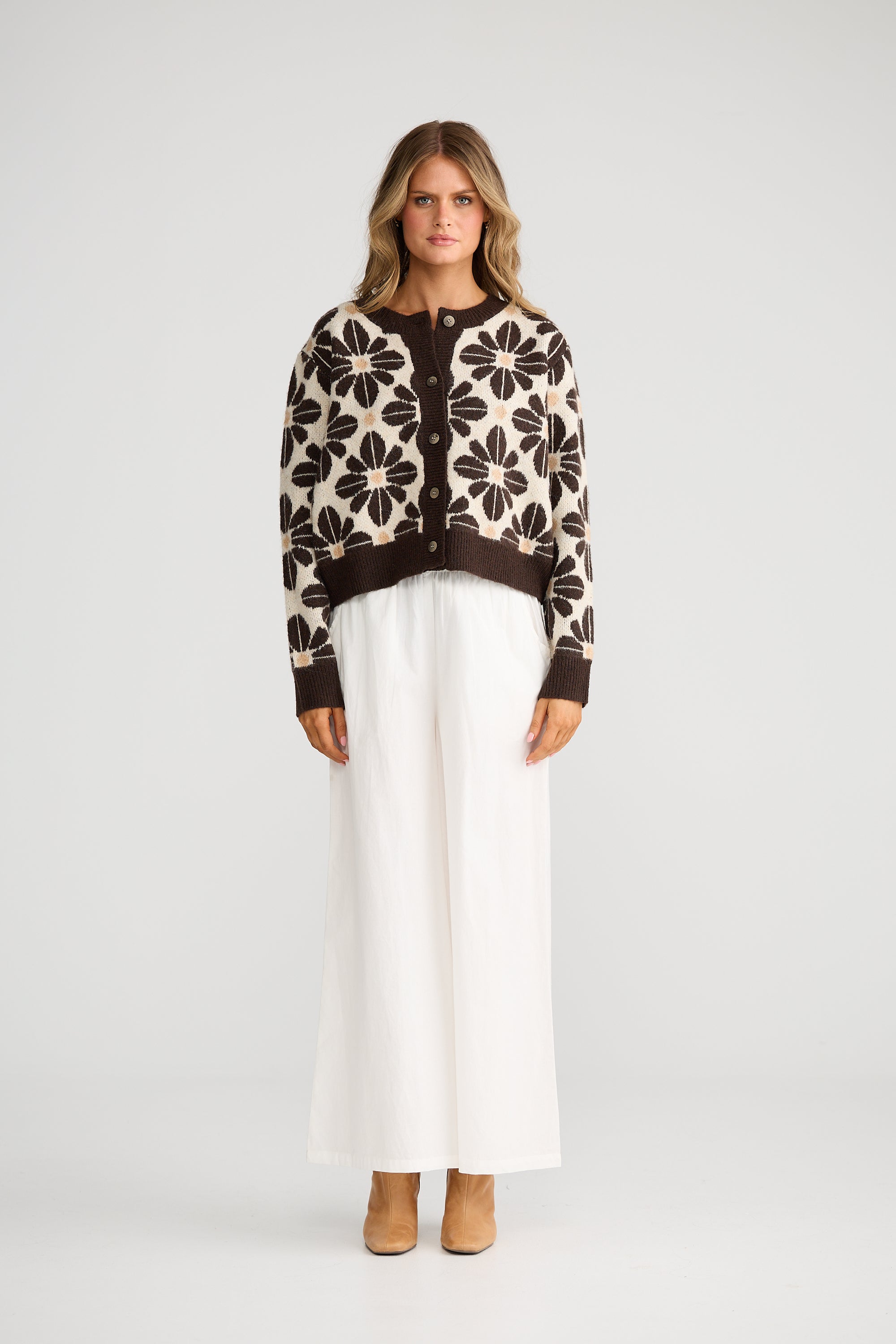 Collection of Woman wearing a Talisman patterned sweater and white pants on a plain background in a gallery layout