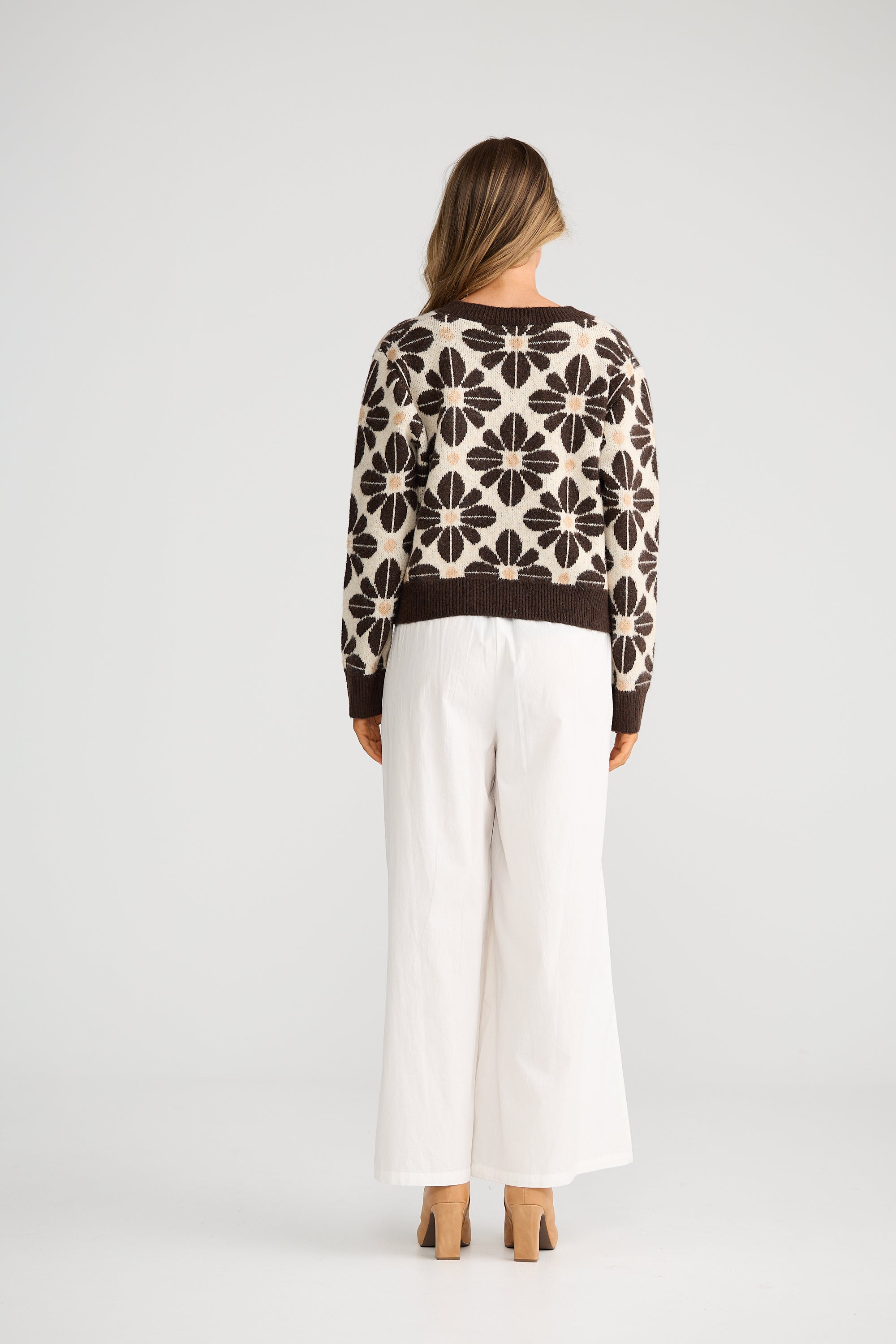 Collection of Woman wearing a Talisman patterned sweater and white pants on a plain background in a gallery layout