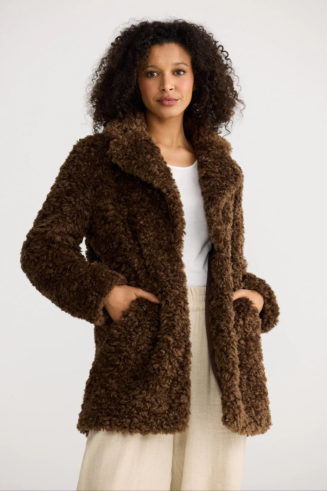 Image of Woman wearing a Shanty Corporation brown fluffy coat on a white background