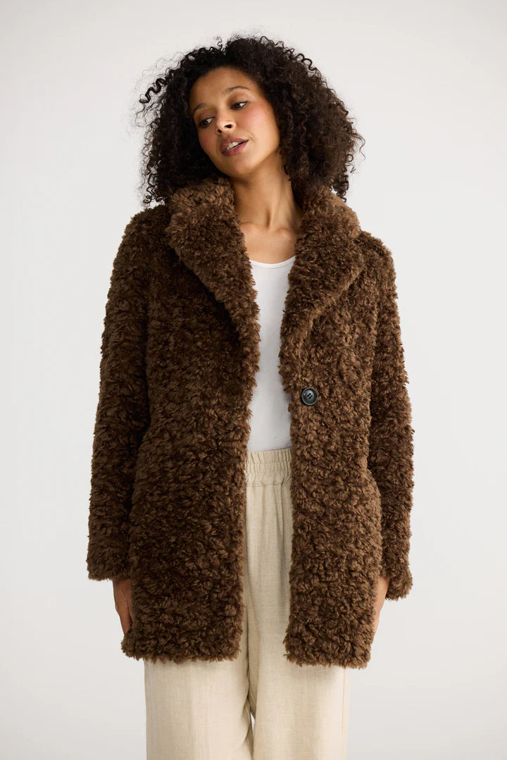 Image of Woman wearing a Shanty Corporation brown fluffy coat against a white background