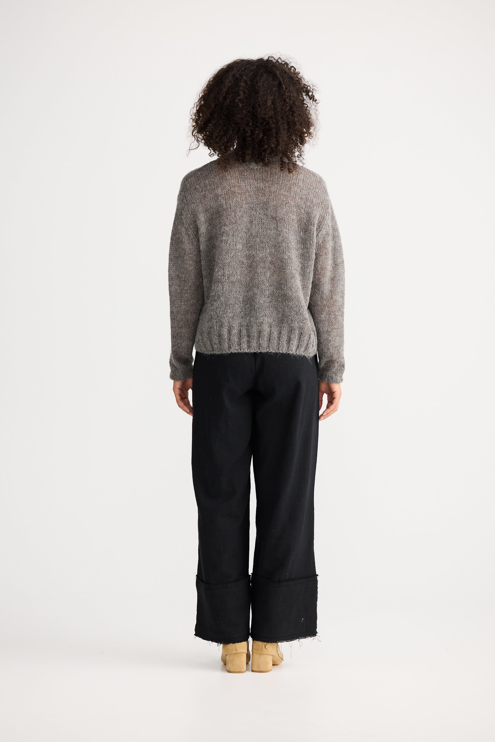 Image of Person wearing a Shanty Corporation grey sweater and black pants on a white background