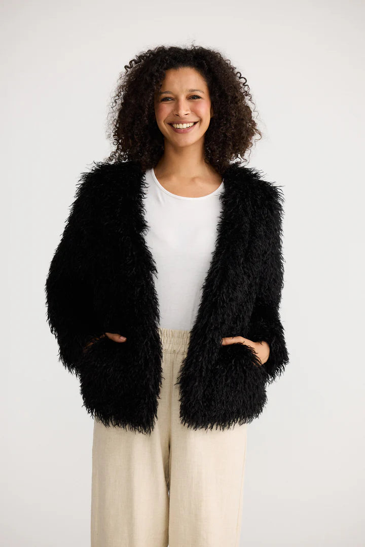 Image of Woman wearing a Shanty Corporation black fluffy jacket on a white background