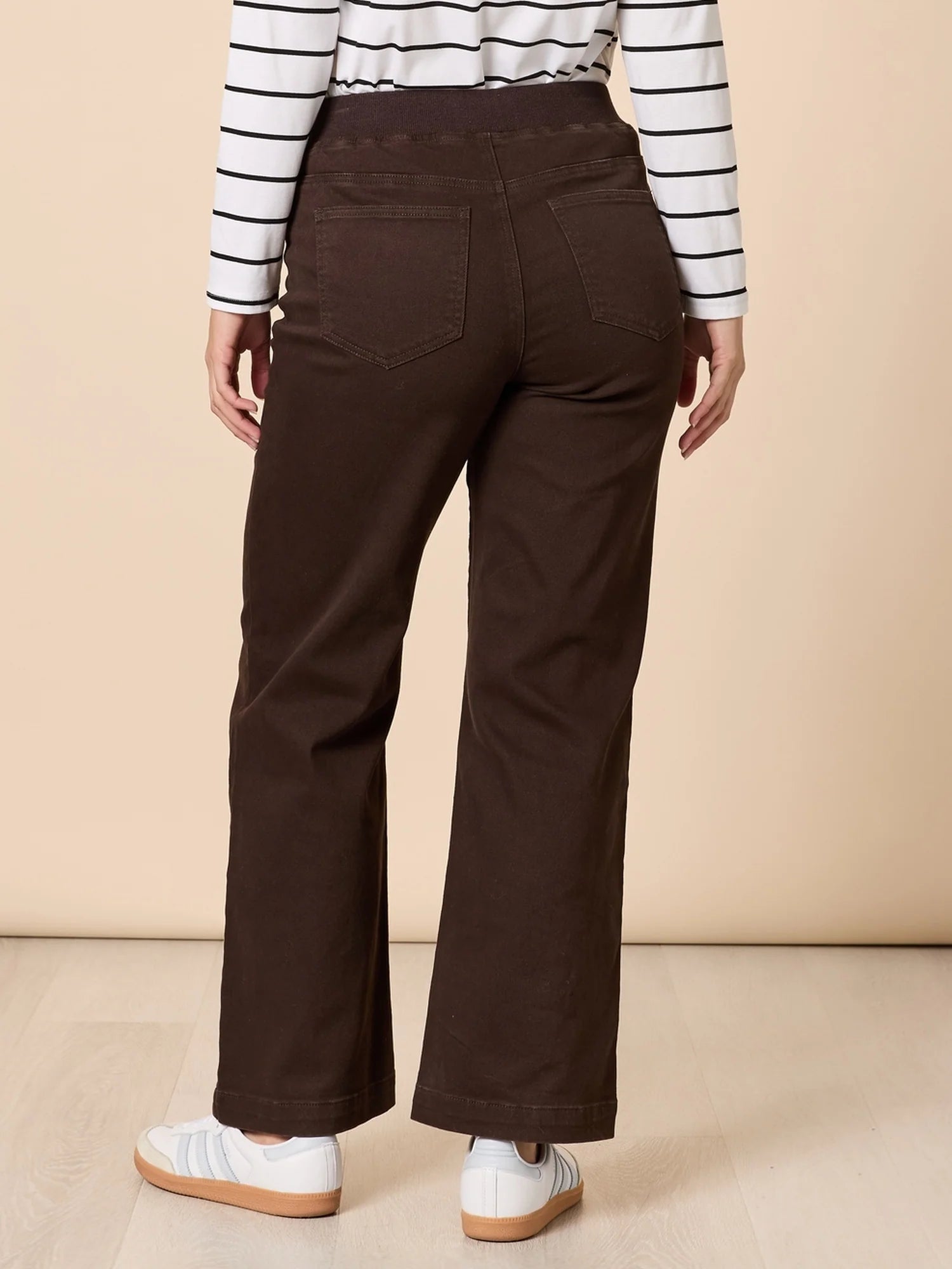 Collection of Woman wearing Threadz brown pants and a striped shirt on a beige background in a gallery layout