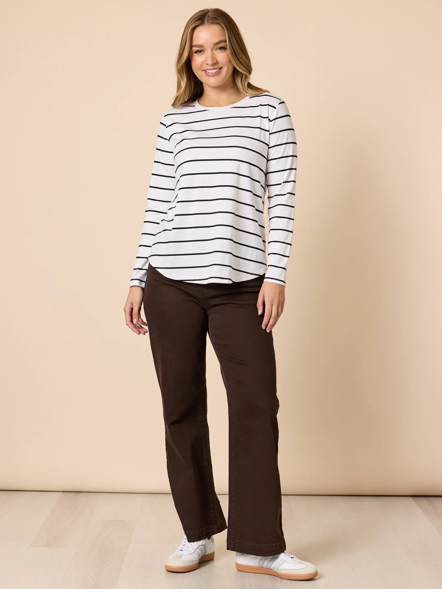 Collection of Woman wearing a striped shirt and Threadz brown pants against a beige background in a gallery layout