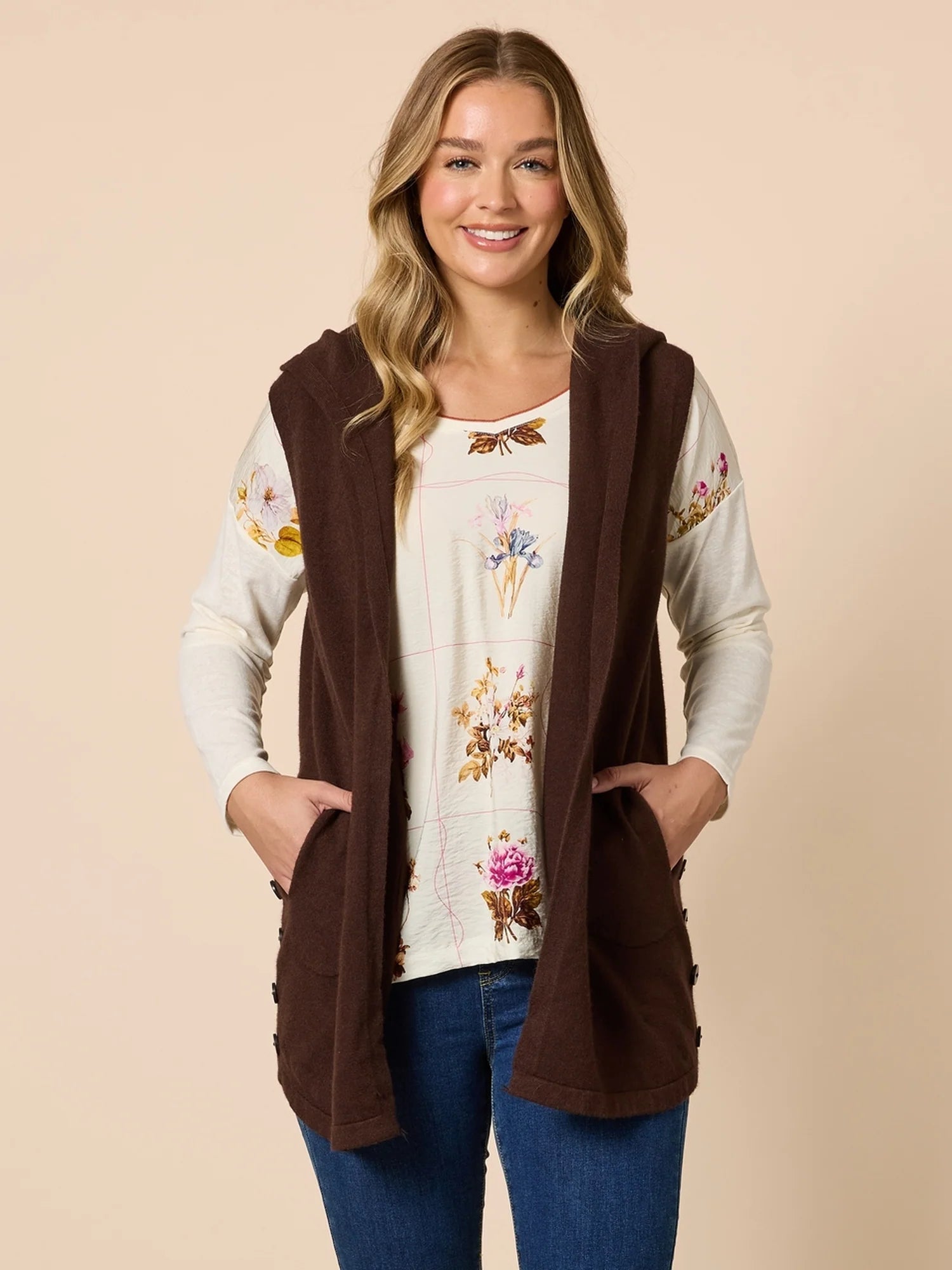 Woman wearing a Threadz brown hooded vest over a floral blouse on a beige background