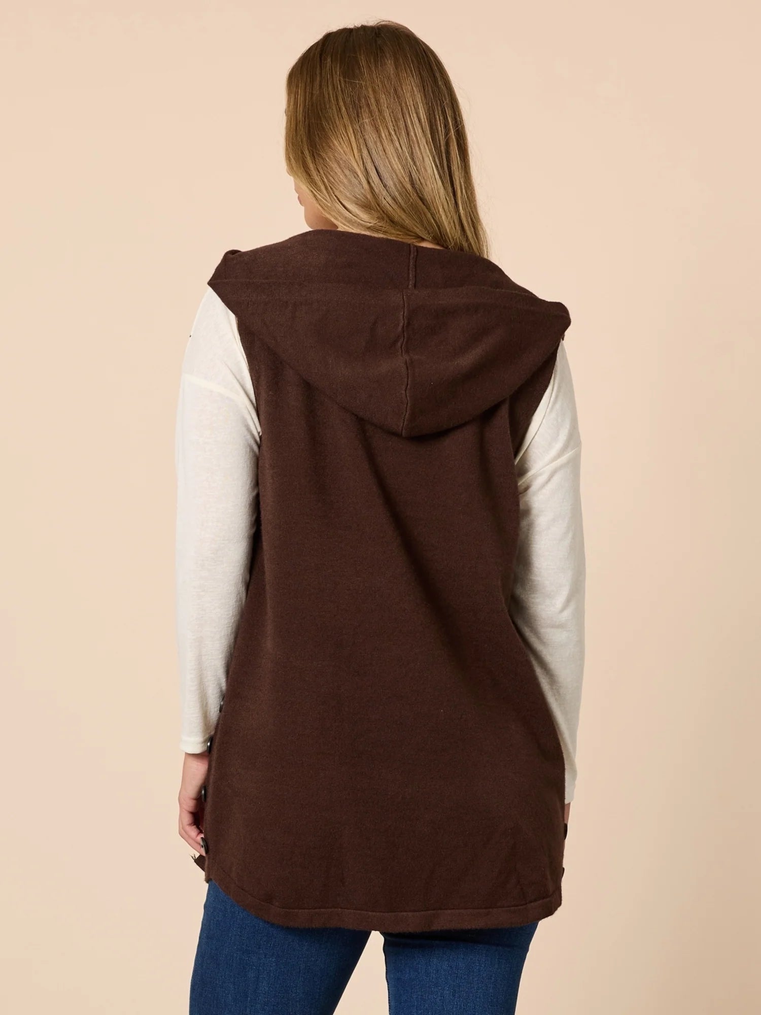 Woman wearing a Threadz brown hooded vest over a white long-sleeve shirt on a beige background
