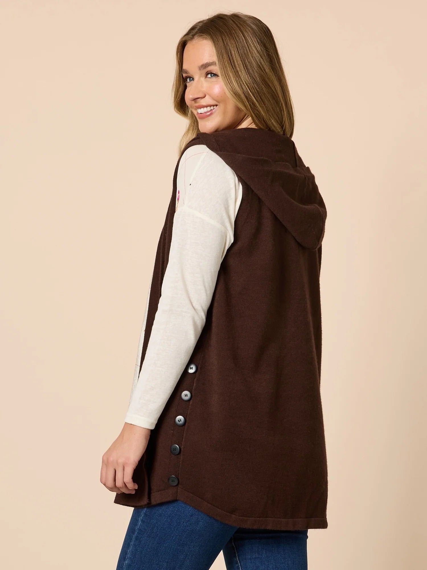 Woman wearing a Threadz brown vest over a white shirt on a beige background