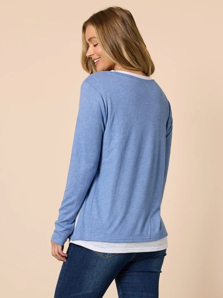 Woman wearing a Threadz blue long-sleeve top on a beige background