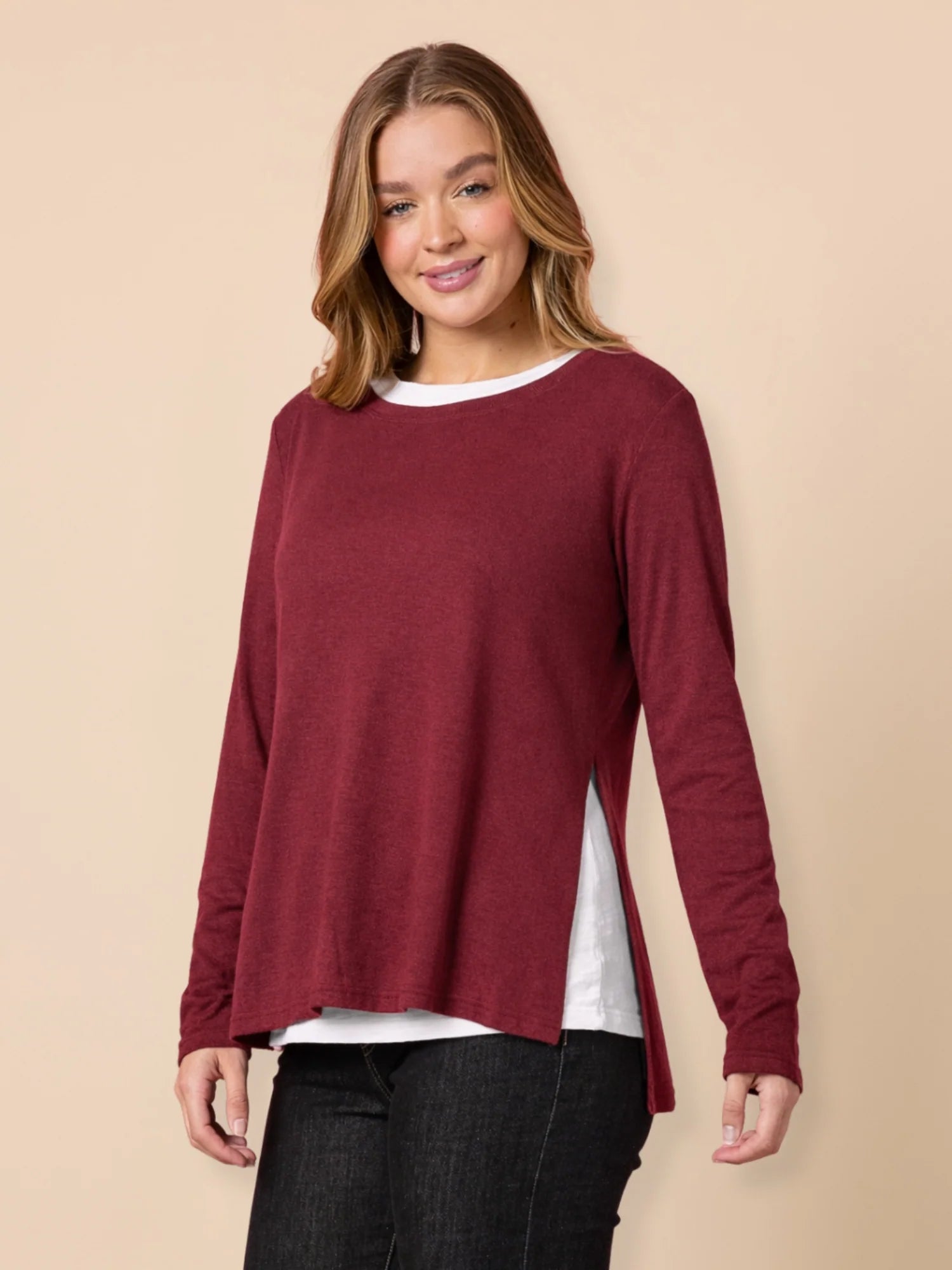 Woman wearing a Threadz burgundy long-sleeve top on a beige background