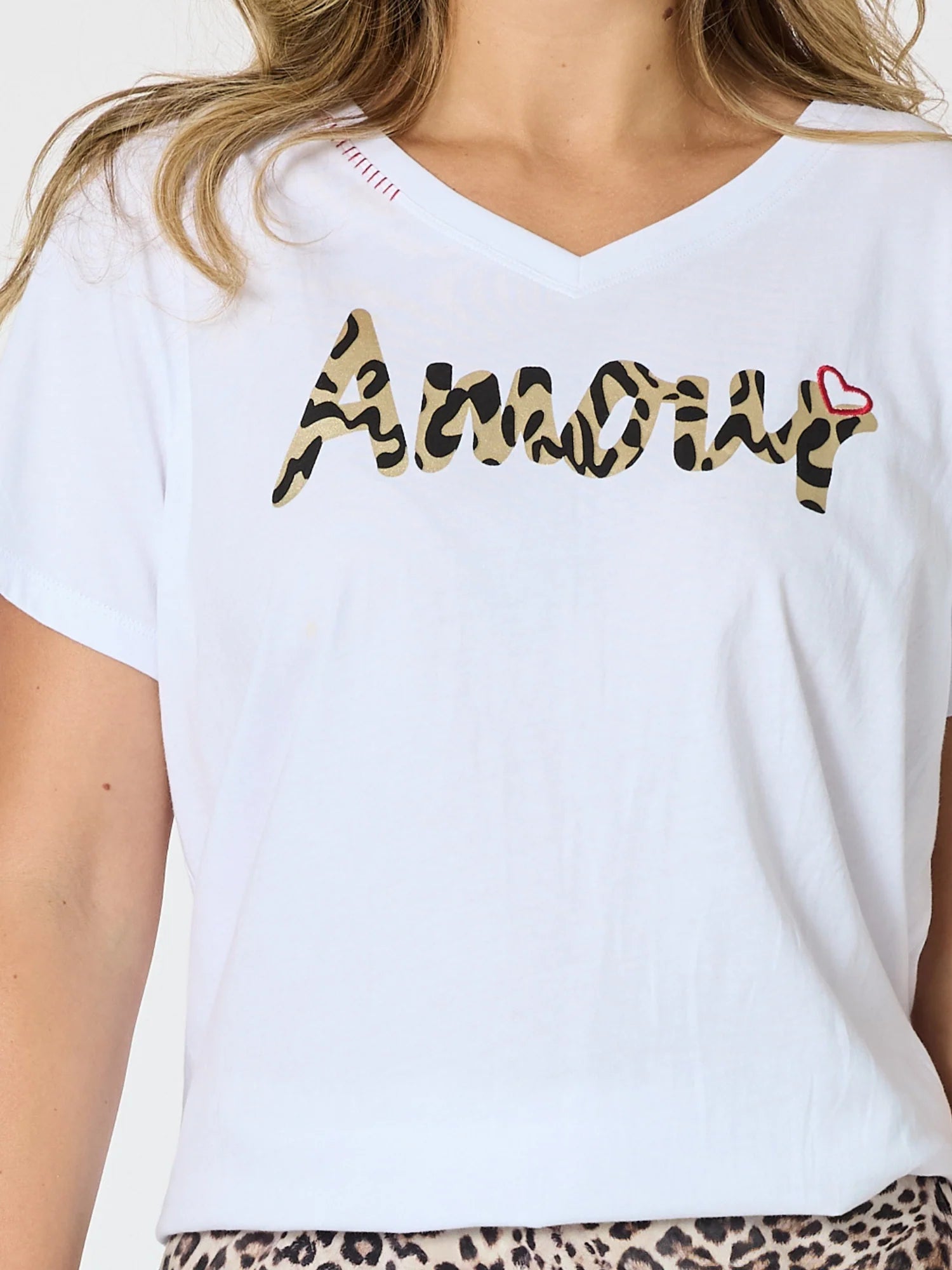Threadz white short-sleeve V-neck T-shirt worn by a model, featuring the word 'Amour' in a leopard print pattern across the chest with a small red heart accent.