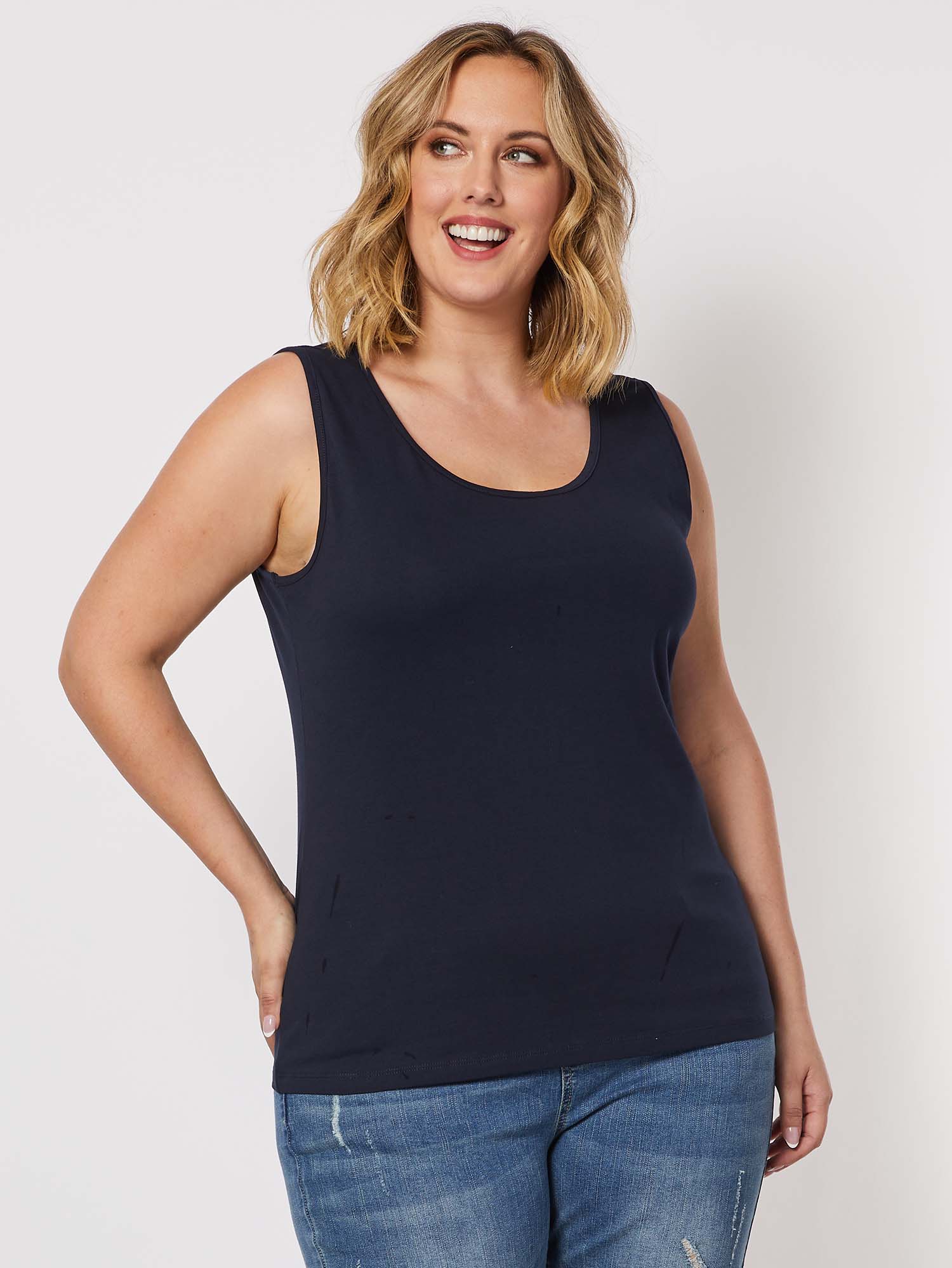 Woman wearing a Threadz navy tank top and blue jeans on a white background