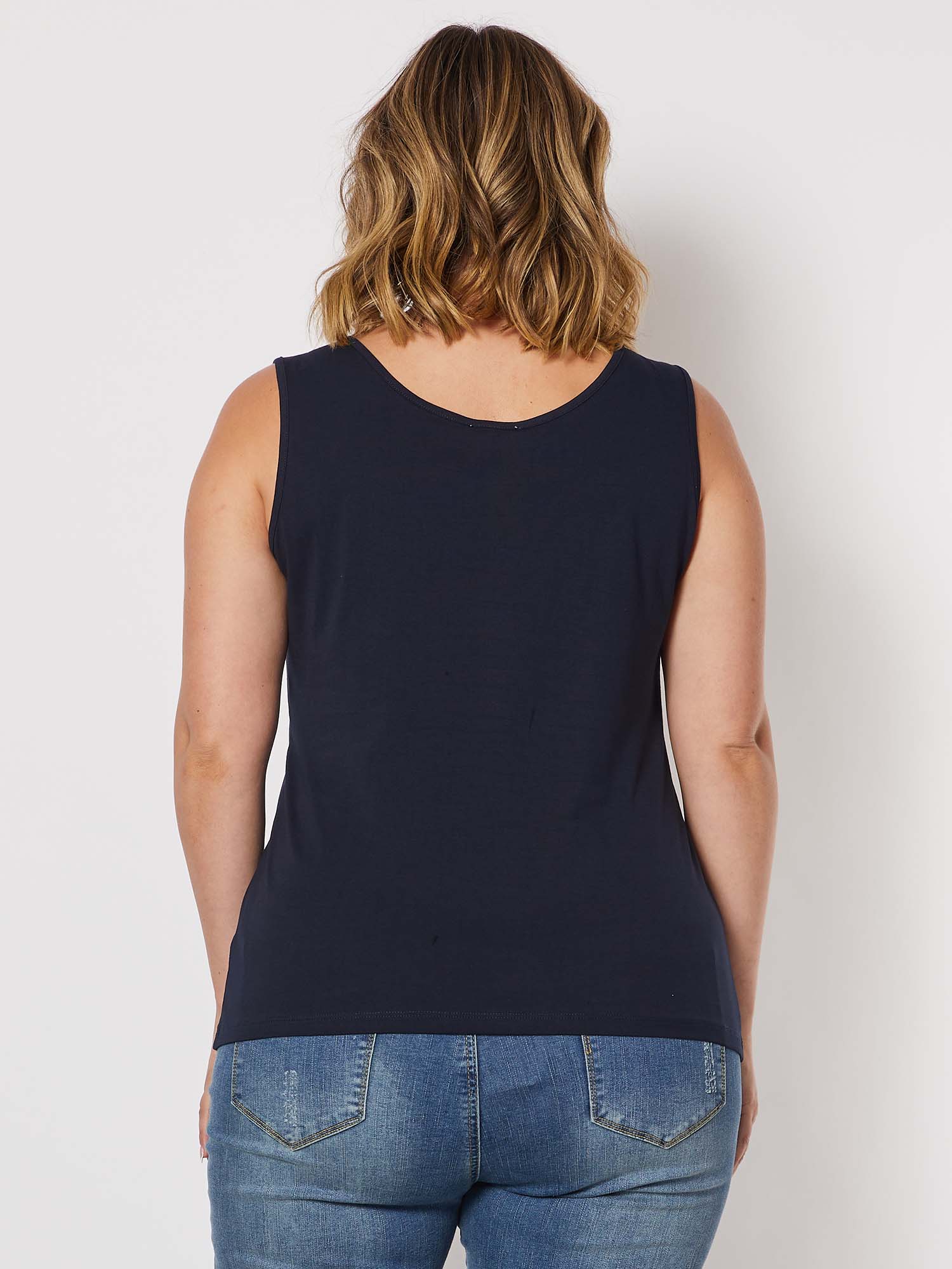 Image of Woman wearing a Threadz navy tank top and blue jeans on a plain background