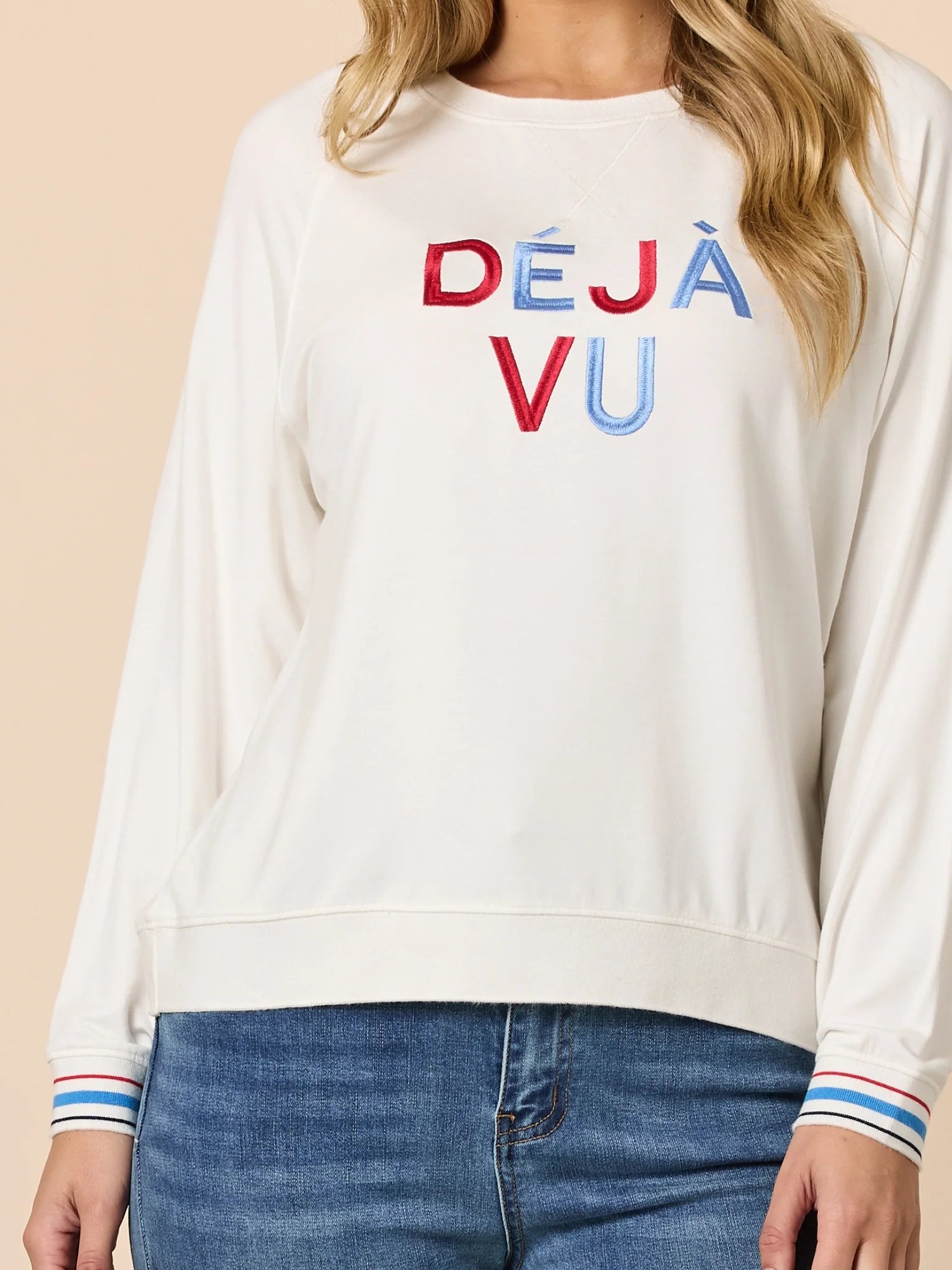 Threadz White sweatshirt with 'DEJA VU' text in red, blue, and purple on a beige background.
