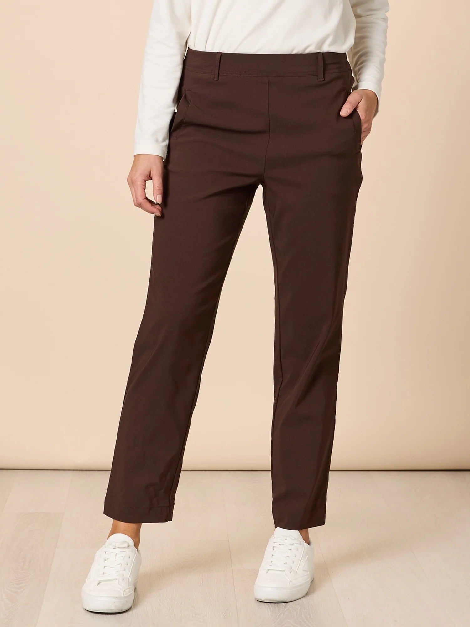 Image of Woman wearing Threadz brown jeans with red stitching on a white background