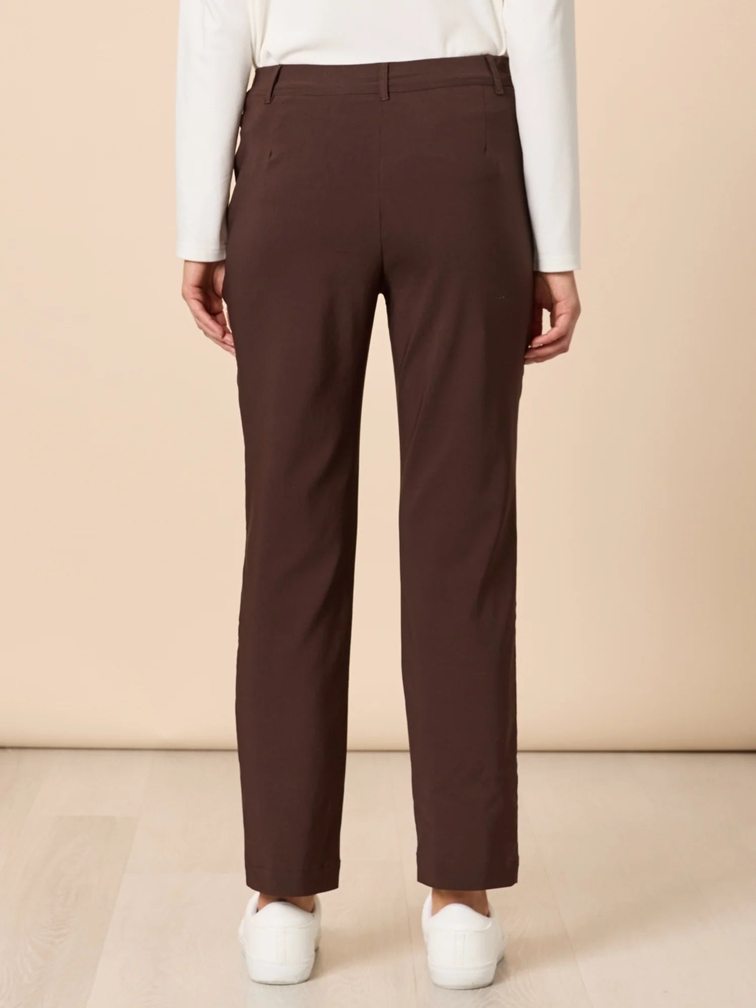 Threadz Brown pants worn by a woman on a beige background