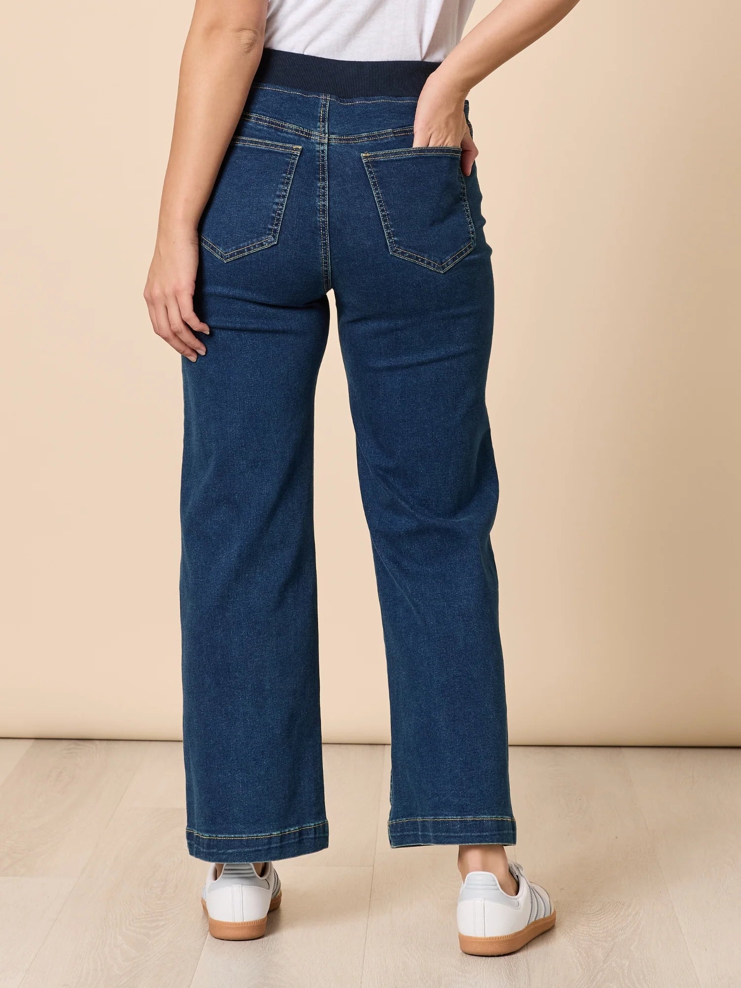 Image of Woman wearing Threadz blue jeans on a beige background