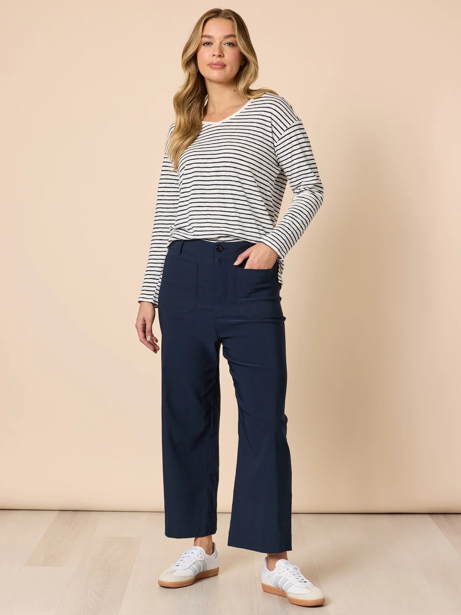 Woman wearing a striped long-sleeve top and Threadz navy wide leg pants against a beige background