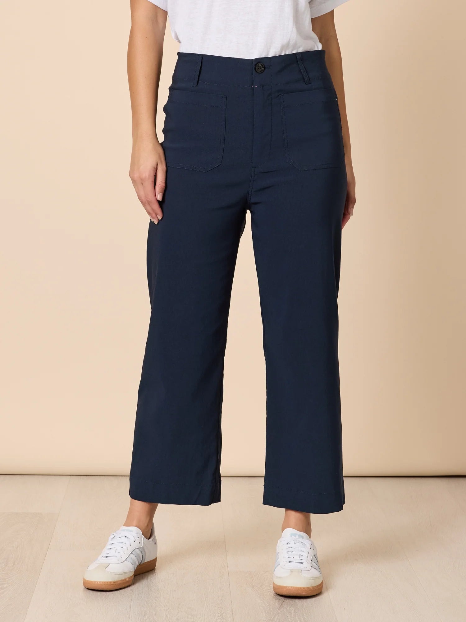 Image of Woman wearing a striped long-sleeve top and Threadz navy wide leg pants against a beige background
