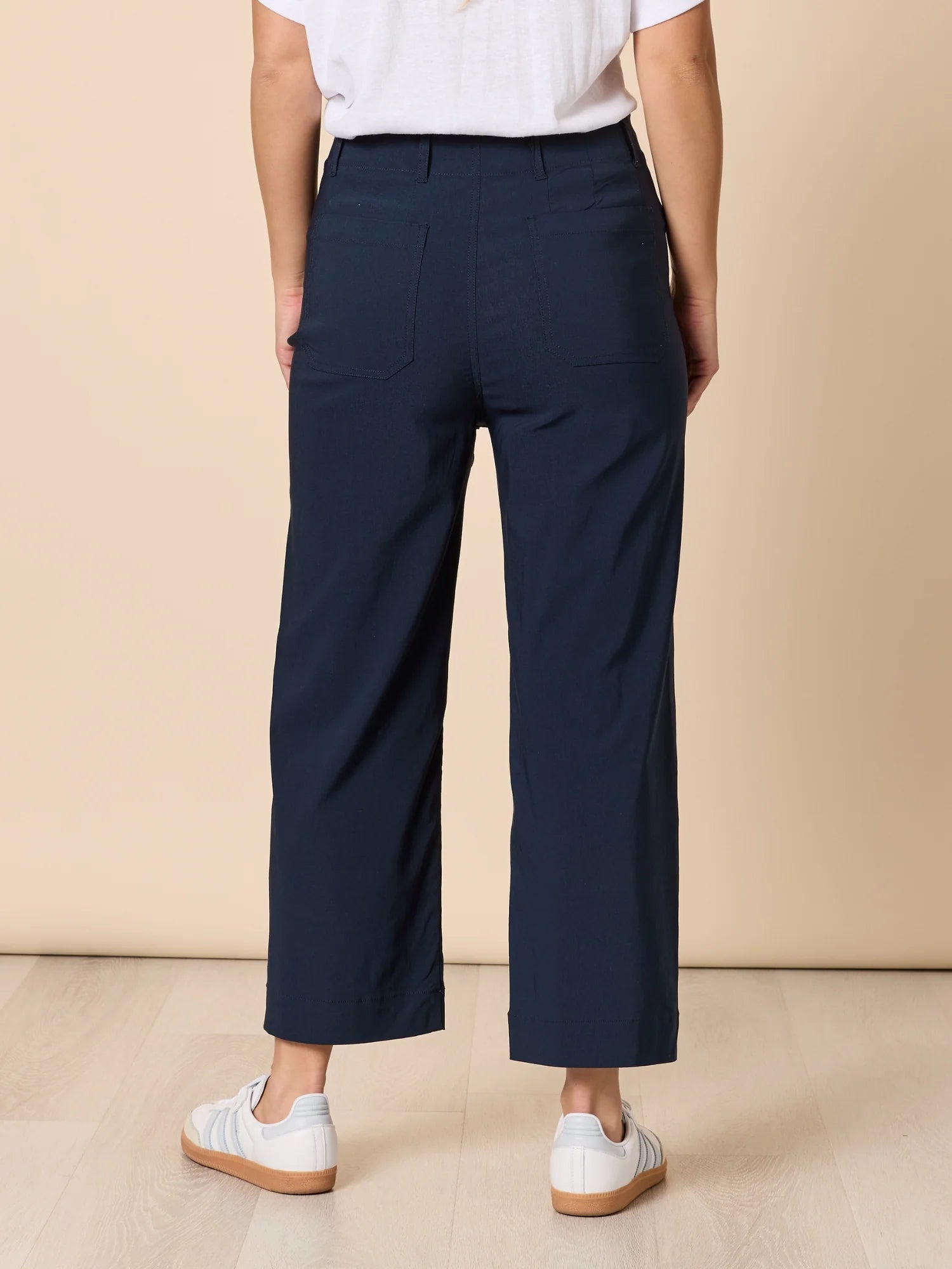 Woman wearing a striped long-sleeve top and Threadz navy wide leg pants against a beige background