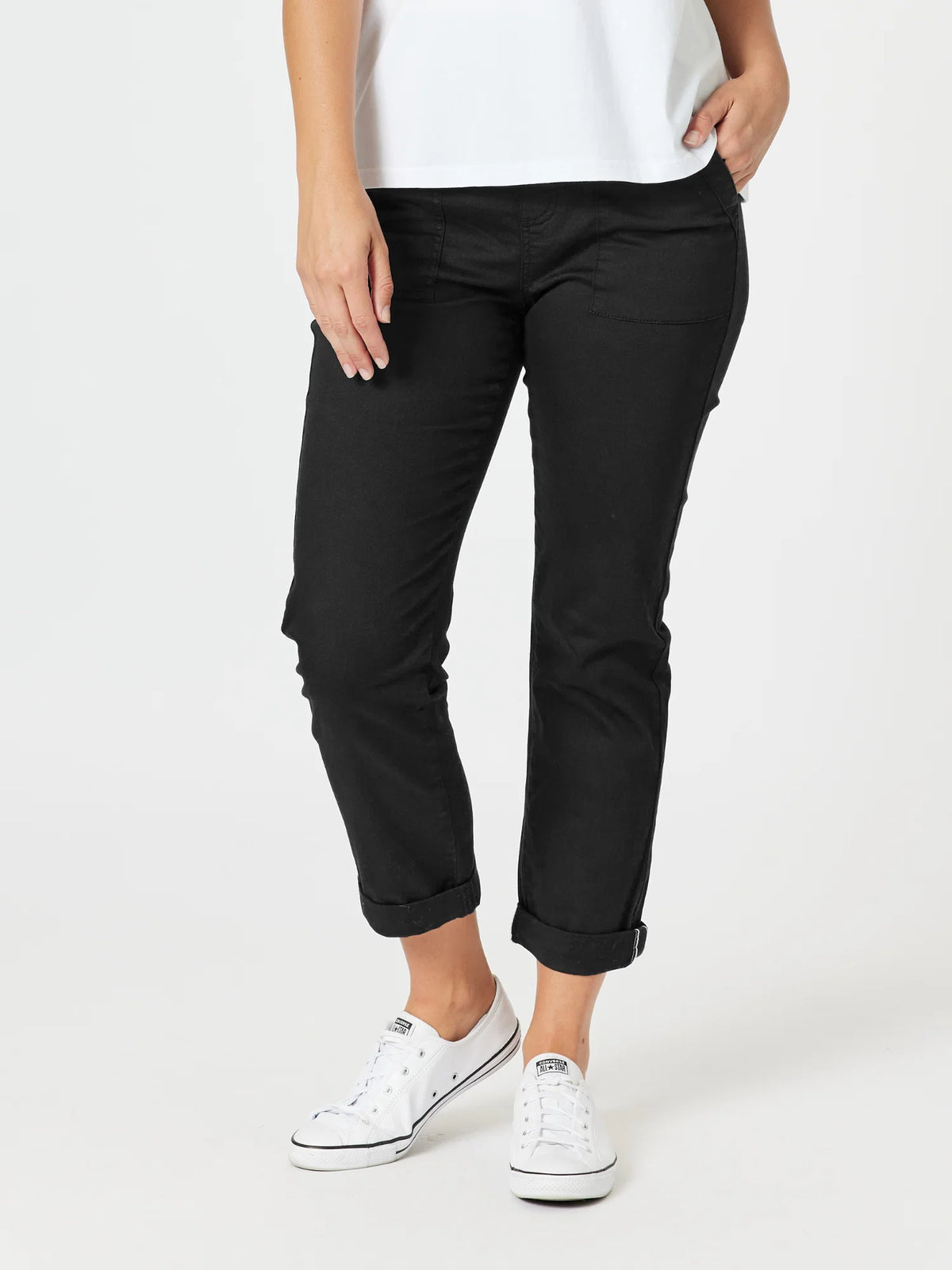 A model wearing Threadz black cropped pants with rolled cuffs, paired with a white t-shirt and white sneakers, shown from the waist down on a light gray studio background.
