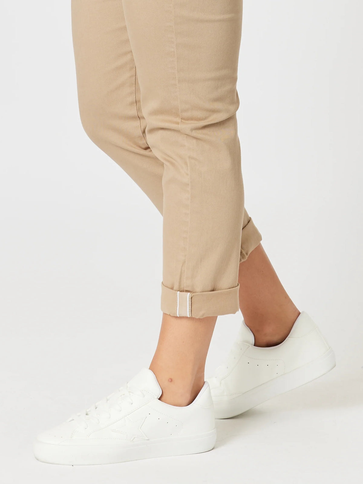 A woman wearing Threadz beige cuffed pants and white low-top sneakers, shown from the knees down against a clean white studio background.