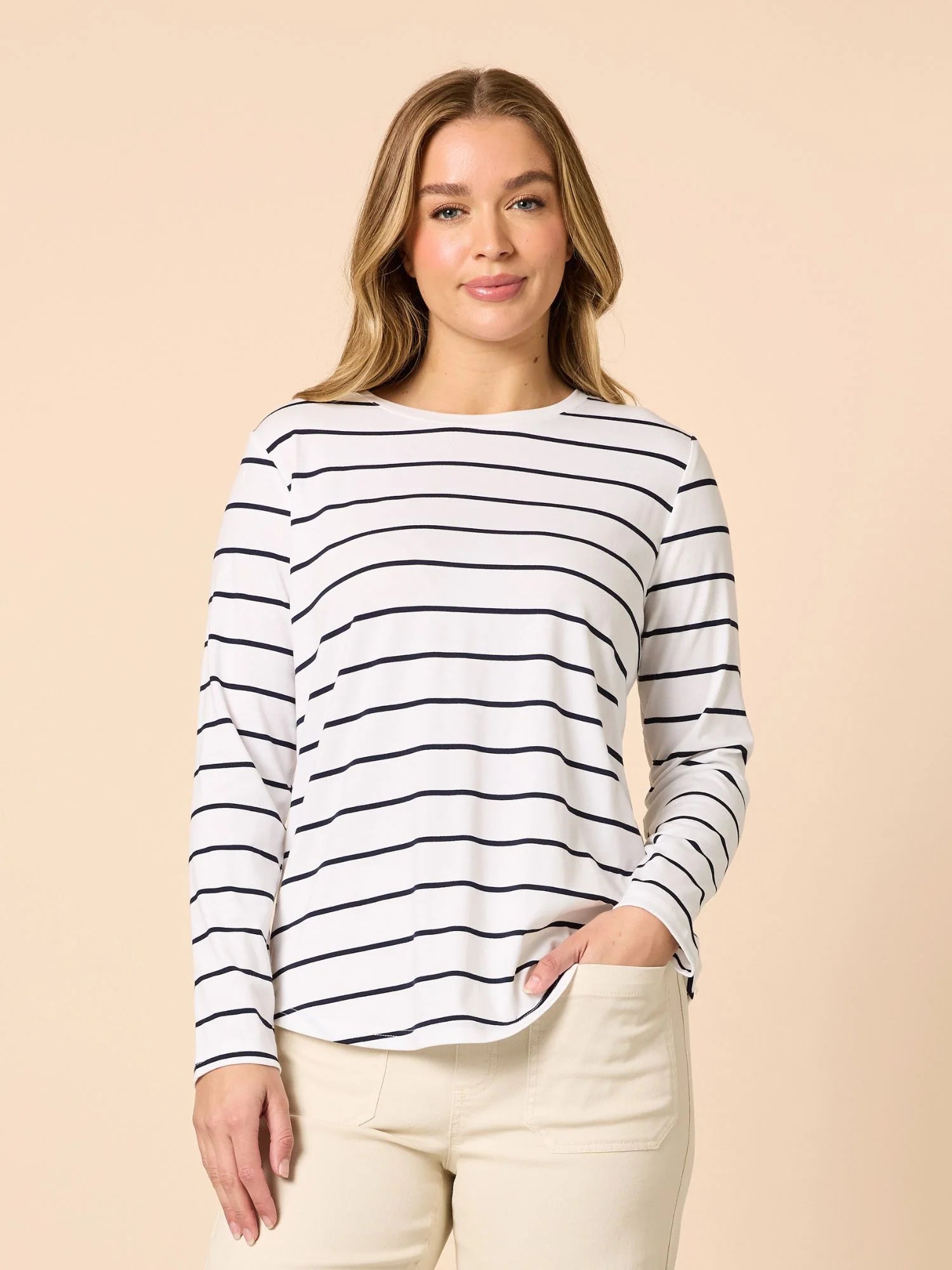Woman wearing a Threadz black and white striped long-sleeve shirt against a beige background