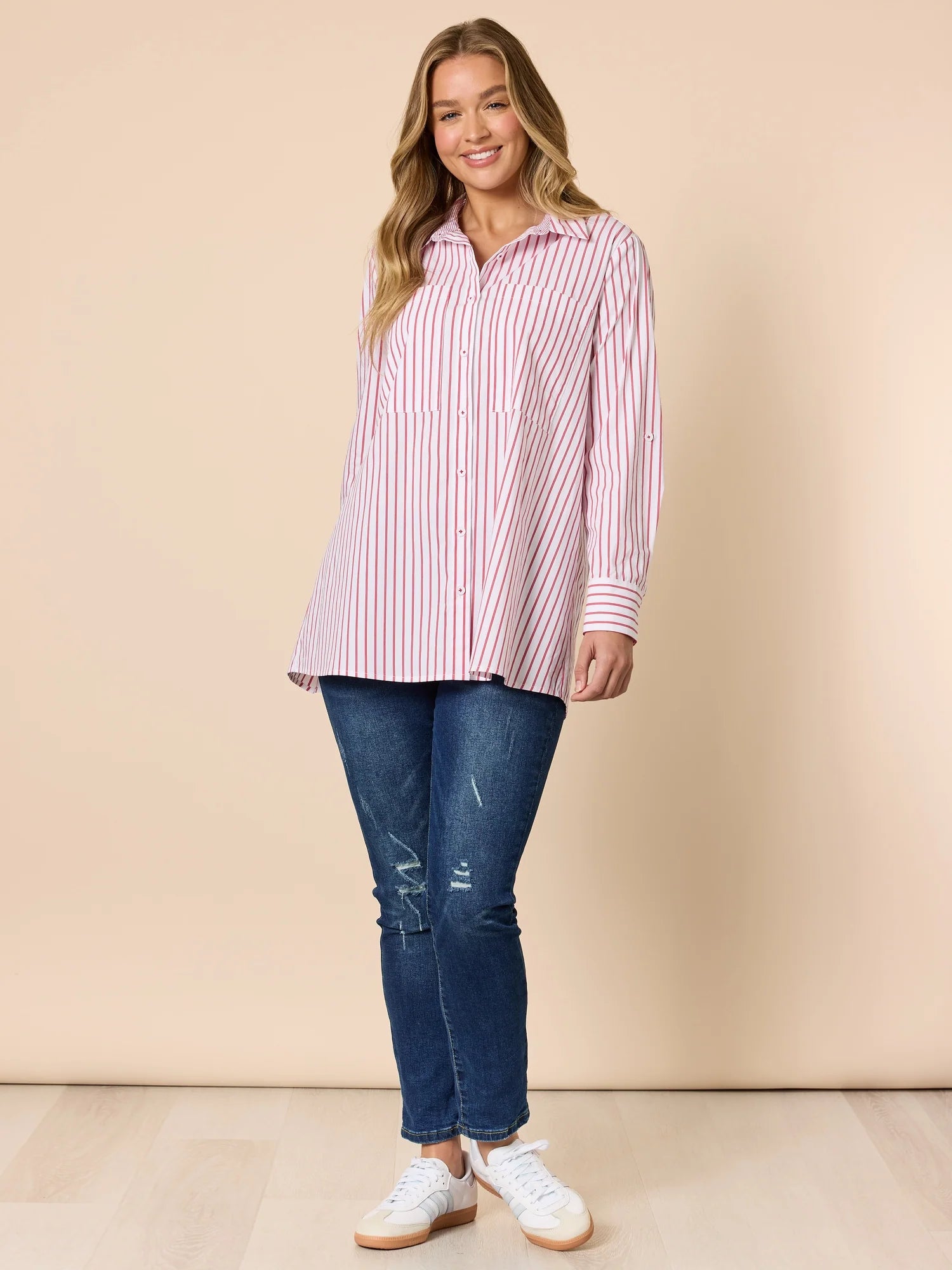 Collection of Woman wearing a Threadz red and white striped shirt with blue jeans against a beige background in a gallery layout